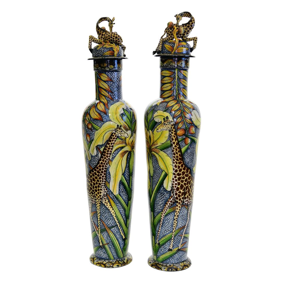 The ceramic Giraffe Urn Pair from Wiseman Ceramics is a masterpiece of African artistry. Hand-sculpted by George and Thabo Mbhele and hand-painted by Wiseman Ndlovu, each urn stands 32 inches tall with dimensions of 7 inches in length and width. The