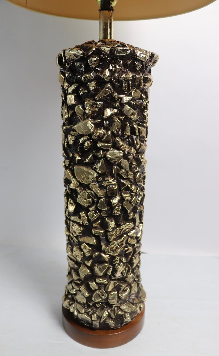 Chic ceramic table lamp having a cylindrical body with a black ground and textured gold nuggets embedded in the surface. Total Glam style, excellent original, clean and working condition, shade not included.
 Total H 36 x H 20.5 to top of ceramic