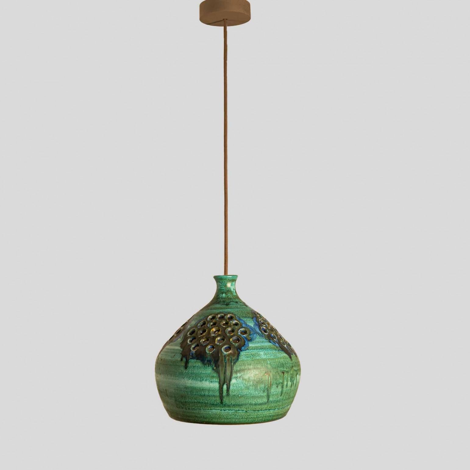 Suspension élégante en céramique fabriquée au Danemark. La lampe est faite de céramique verte, brune et bleue et est percée de trous, ce qui lui confère une belle luminosité.

Une pièce unique dans la pièce.

Nettoyé, bien câblé, en parfait état de