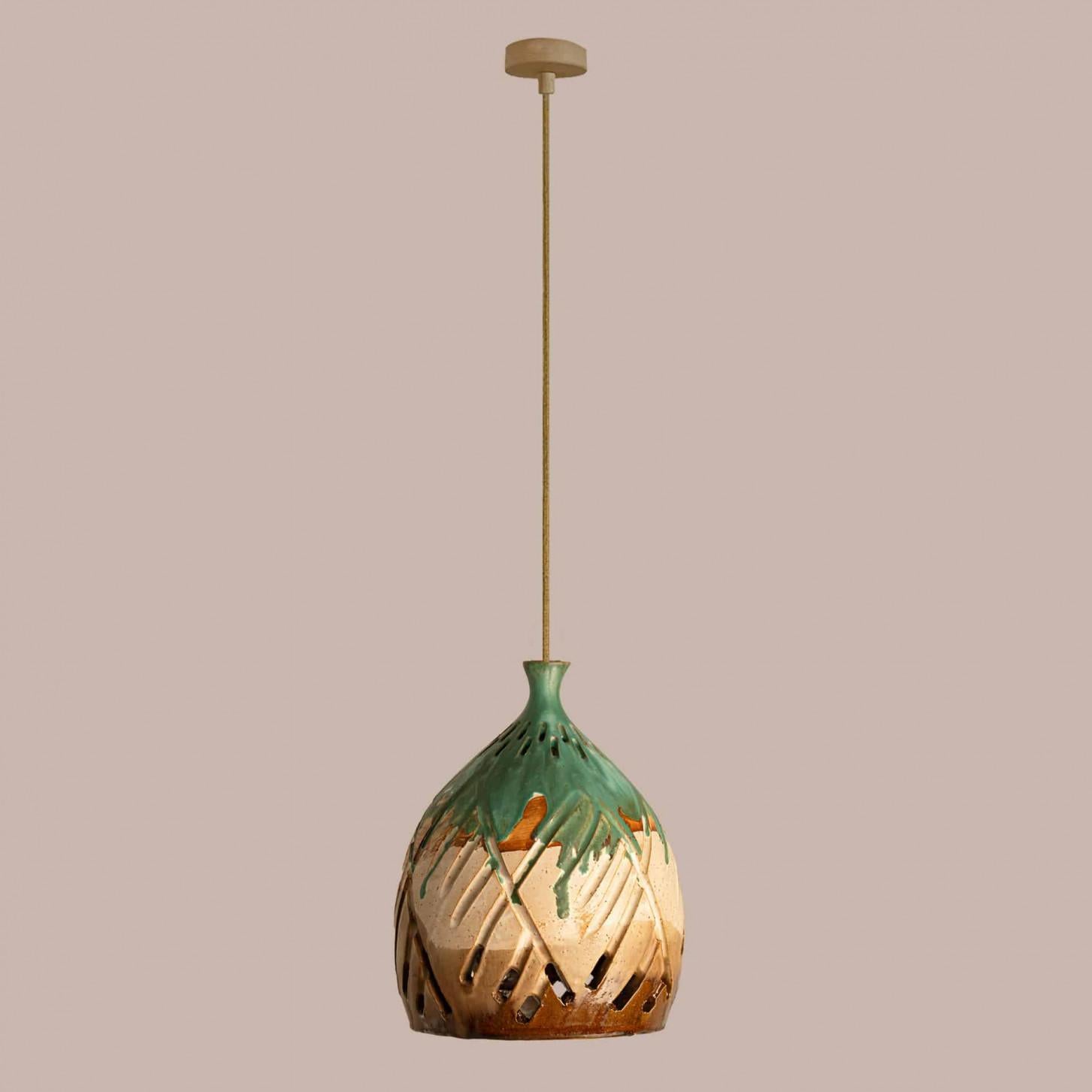 Elegante lámpara colgante de cerámica fabricada en Dinamarca. La lámpara está hecha de cerámica verde, marrón y beige y tiene un patrón geométrico de líneas y agujeros, por lo que ilumina de maravilla.

Una pieza única en la habitación.

Limpio,
