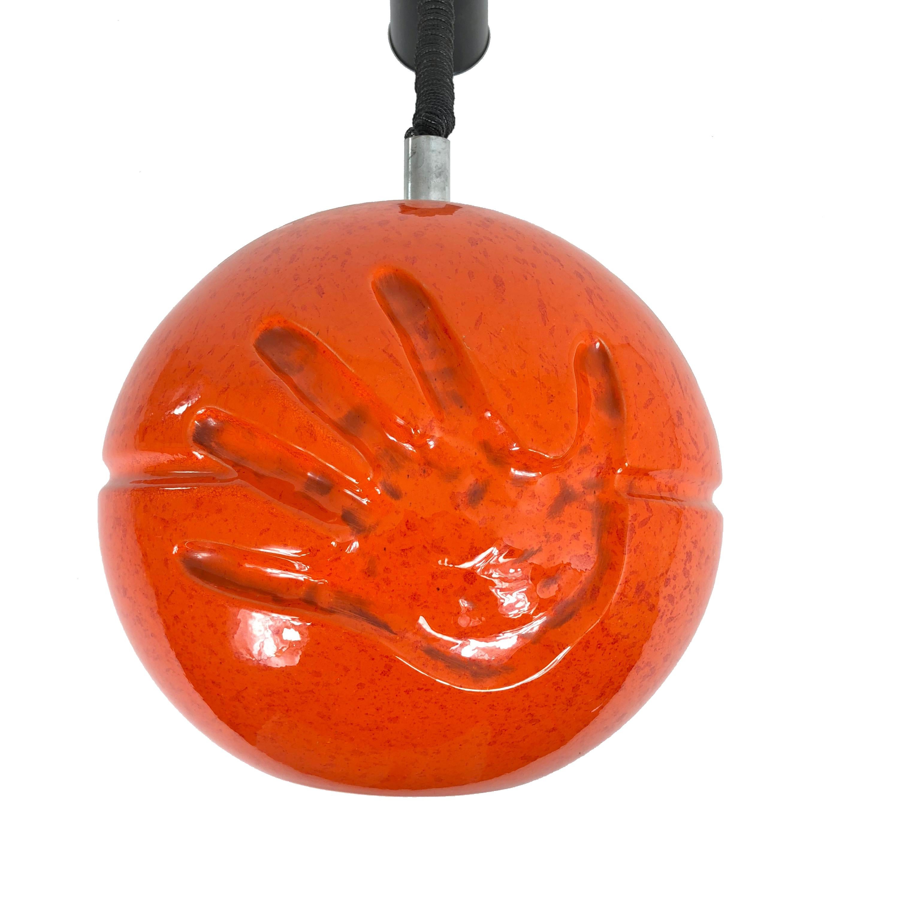 Rare spherical chandelier in lacquered orange ceramic attributed to Il Picchio. It has two imprinted hands on both sides. 
Perfect conditions.