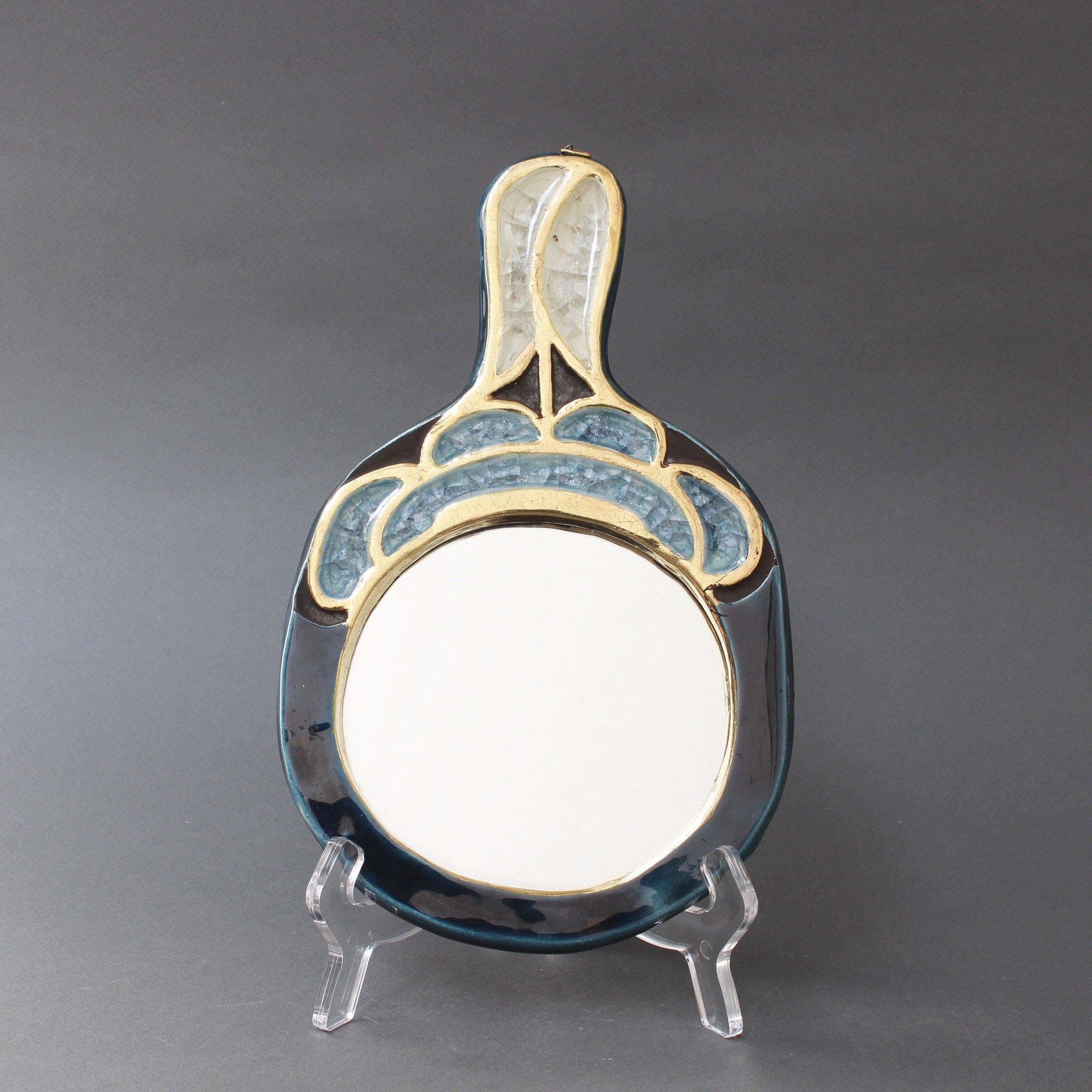 Ceramic oval hand mirror by Mithé Espelt (circa 1960s). A diminutive, elegant work of decorative art partially covered in gold crackle ceramic glaze complemented by a rich blue. Inlaid within geometric shapes in the blue enamel and outlined in the