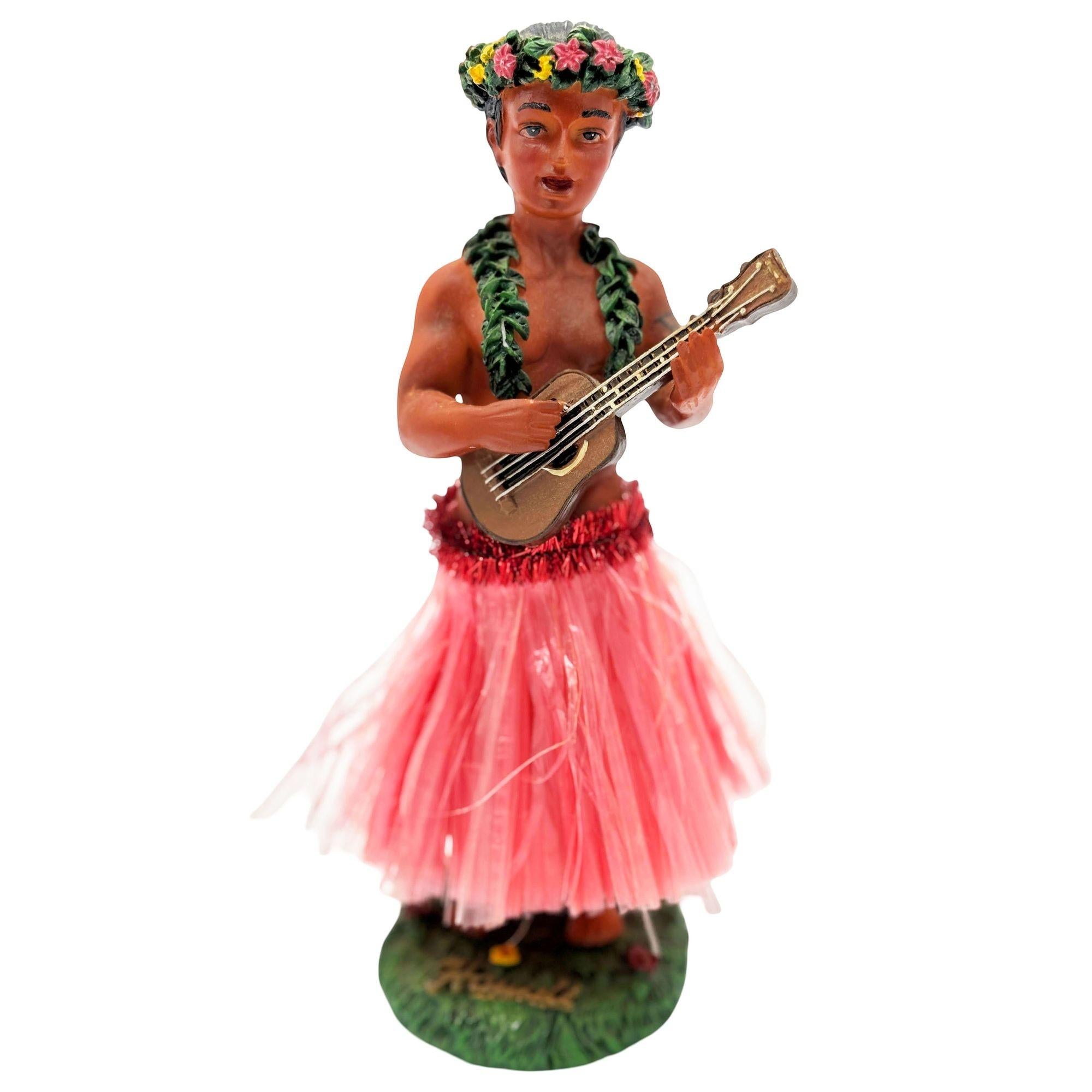 Original ceramic bobble doll Hawaiian hula boy playing a Ukulele made from lightweight plaster and painted in vibrant tropical colors. It depicts a young Native Hawaiian boy with a Ukulele in hand and a floral headdress.

Signed: