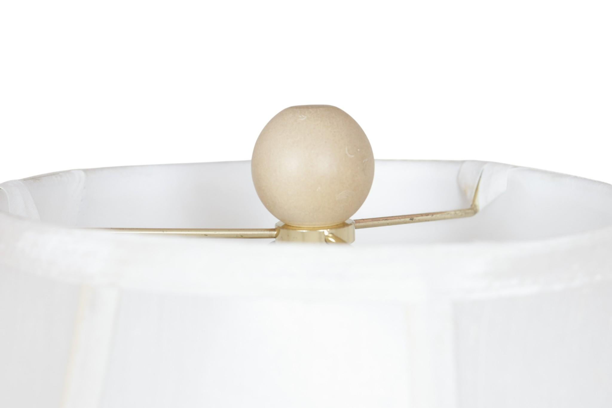 Lampe de table en céramique gaufrée de style côtier du milieu du siècle. Le vase central est orné de hérons et de graminées en relief de couleur crème, décorés d'une glaçure fauve mouchetée. Un abat-jour en forme de cloche peu profonde en lin blanc