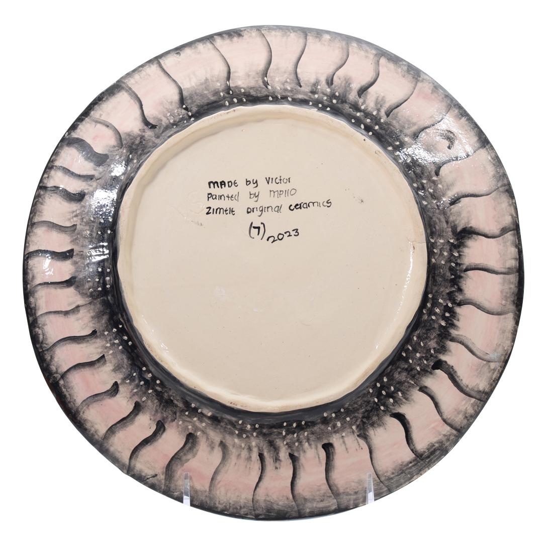 The Ceramic Hippo Plate from Zimele Ceramics in South Africa is a beautifully crafted piece, measuring 1 inch high, 11 inches long, and 11 inches wide. Hand-sculpted by Victor Shabalala and hand-painted by Nompilo Zaba, this plate showcases a