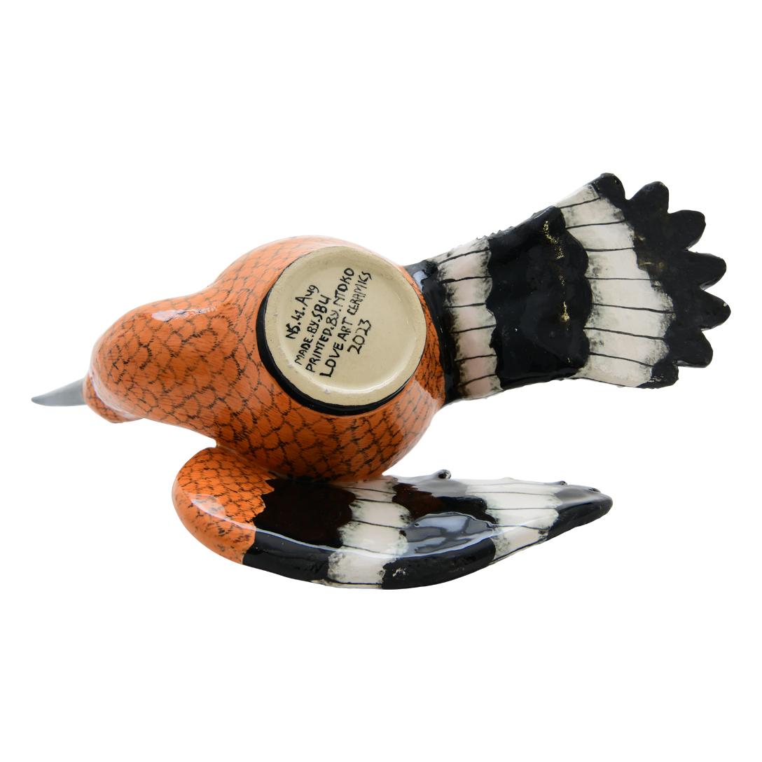 This hoopoe jewelry ceramic box is a true treasure, meticulously crafted by hand and painted with care by South African artists. Its unique design features one of the wings serving as a removable lid, adding a touch of whimsy and charm to the piece.