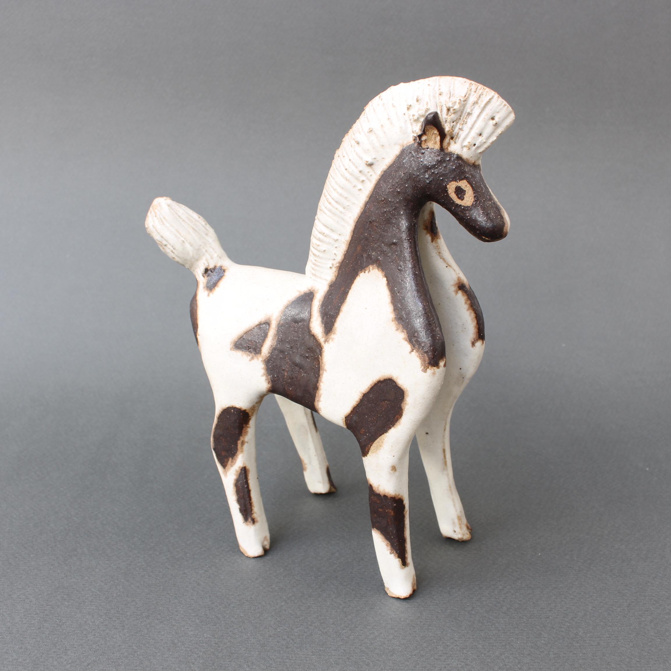 Ceramic two-toned horse by ceramicist Bruno Gambone, (circa 1980s). A charming ceramic parade horse with groomed mane and tail in Gambone's signature chalk-white glaze. That glaze is beautifully complemented by chocolate-brown markings on the