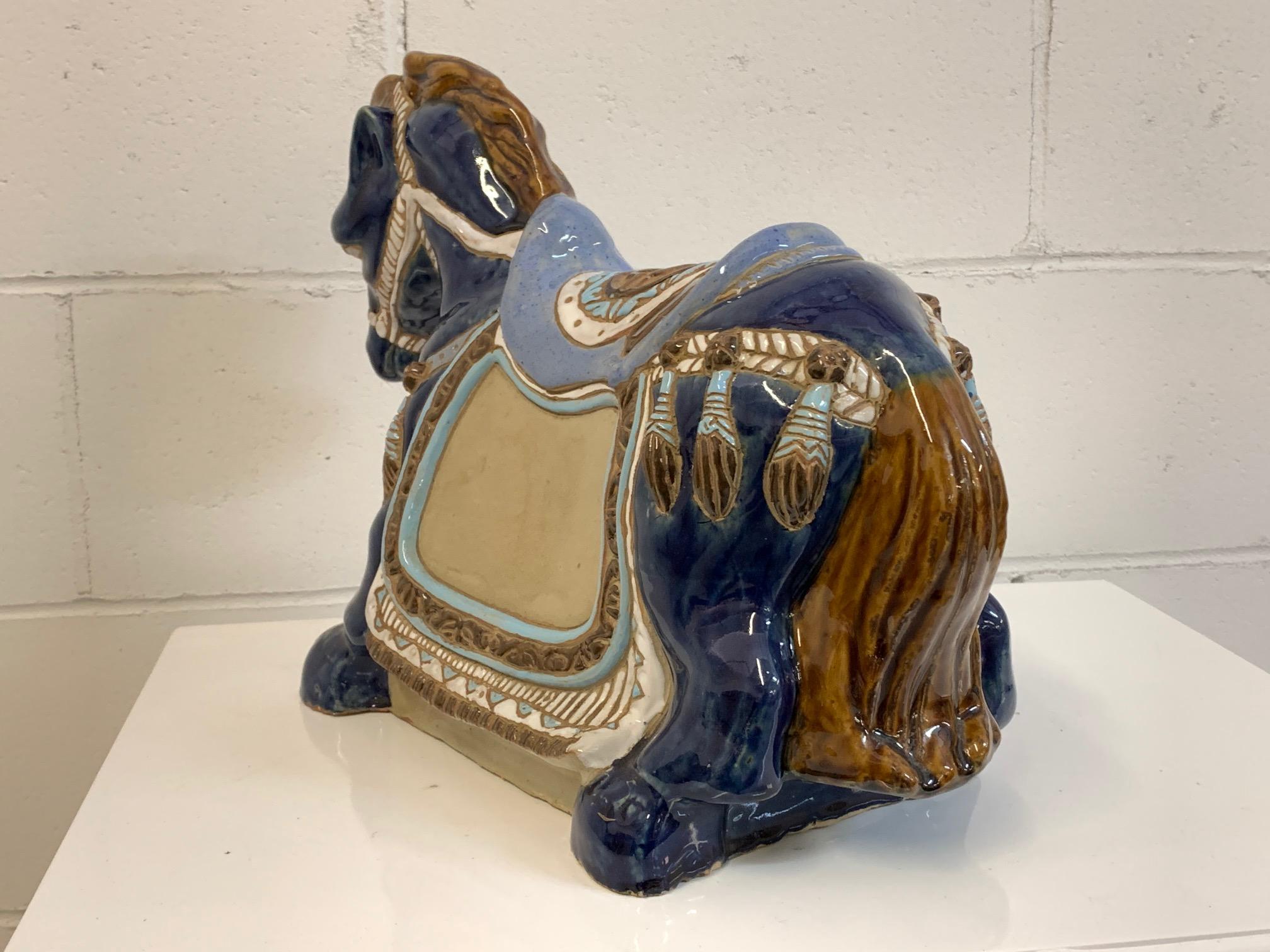 Handsome ceramic horse statue in glossy glazed blue with multicolored detailing. Stands 12.5