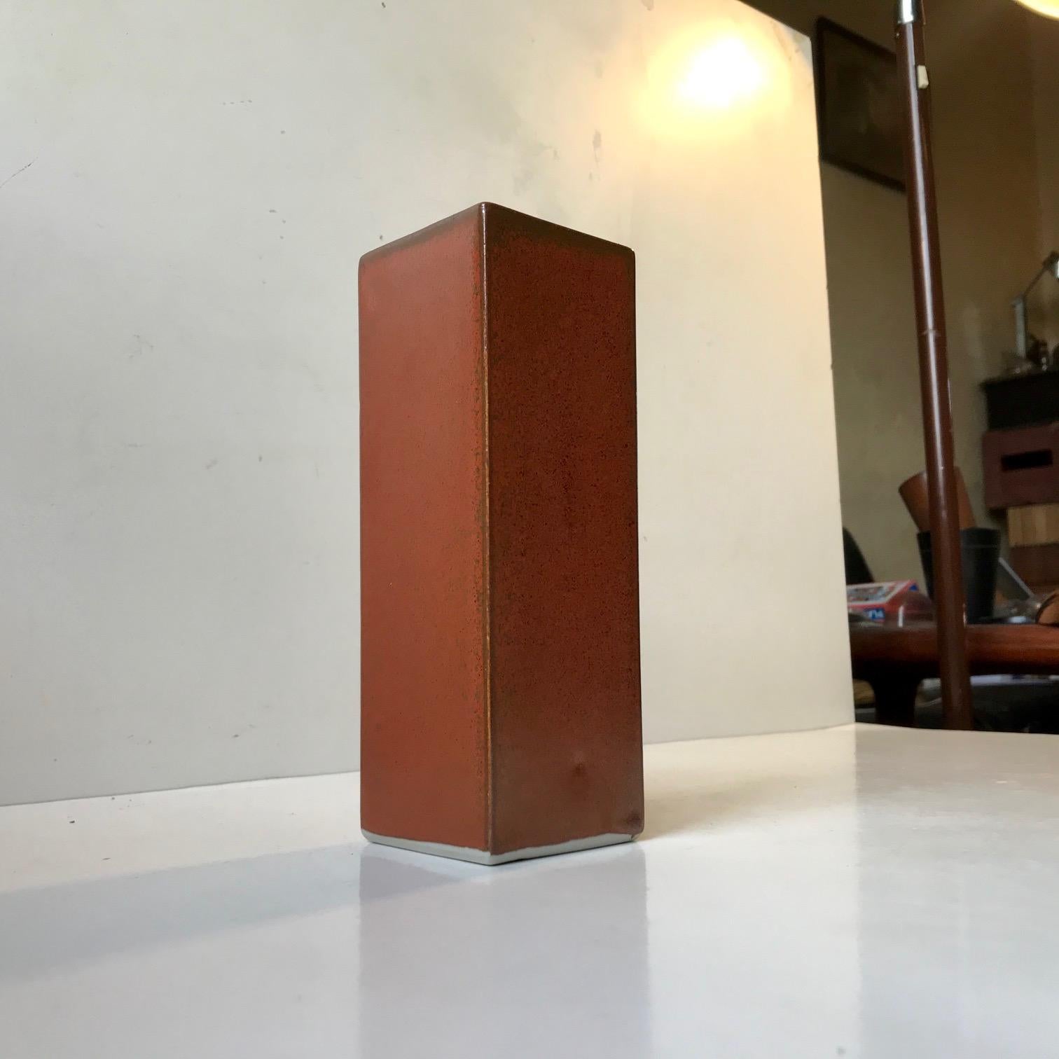 A rectangular Japanese Ikebana vase in orange with speckles in earthy brown/green glazes. Ikebana is the Japanese equivalent of arranging flowers. The vase has a label from Yamasan to the base and was made during the 1970s. The vase is intact and