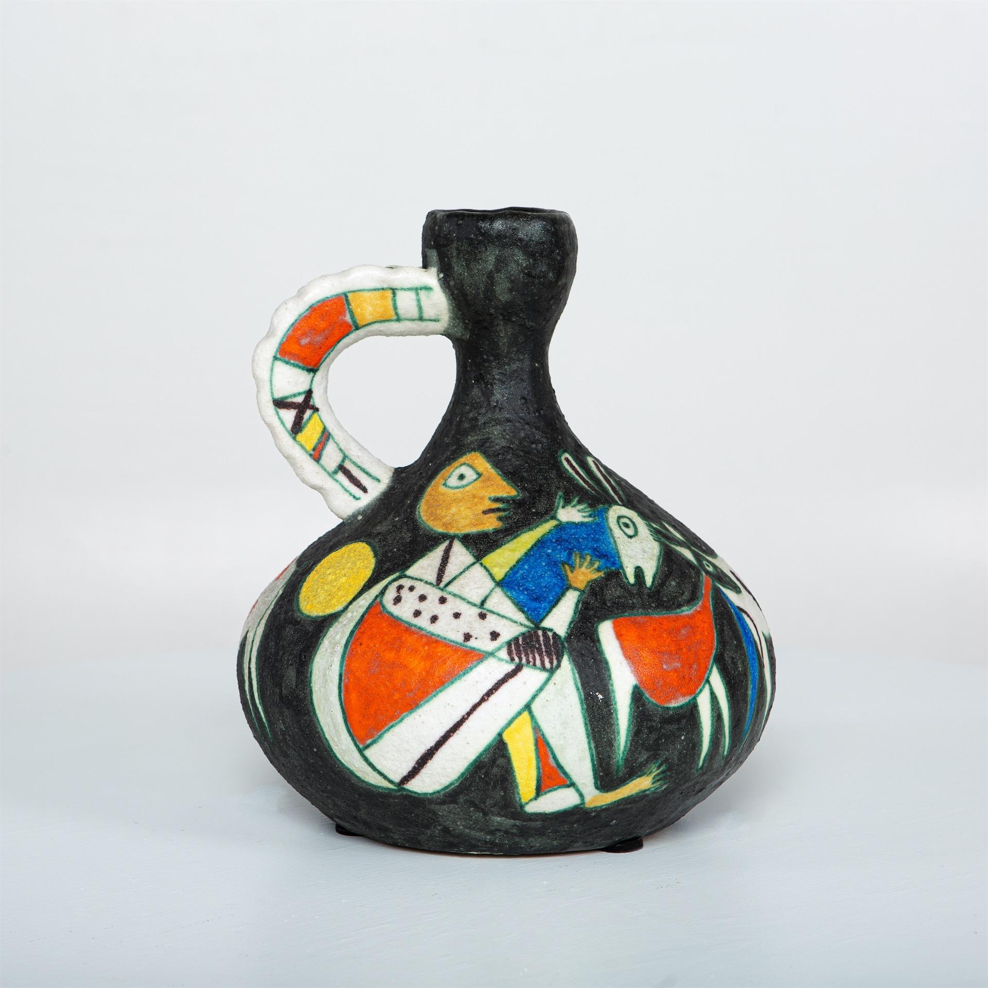 Large heavy carafe in polychrome glazed ceramic with handle and potbellied wall by Guido Gambone. The wall shows cubistic abstract people and animals in primary colors on a black background.