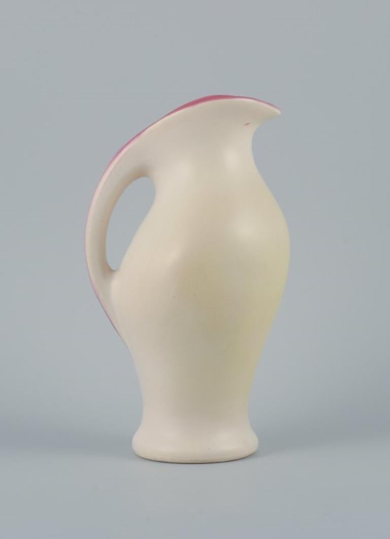 Ceramic jug in matt white glaze. In style of Pol Chambost (1906-1983).
Interior decorated in rose colour.
Organic form.
Approx. 1960.
In perfect condition.
Dimensions: H 26.0 x D 15.0 (including handle)