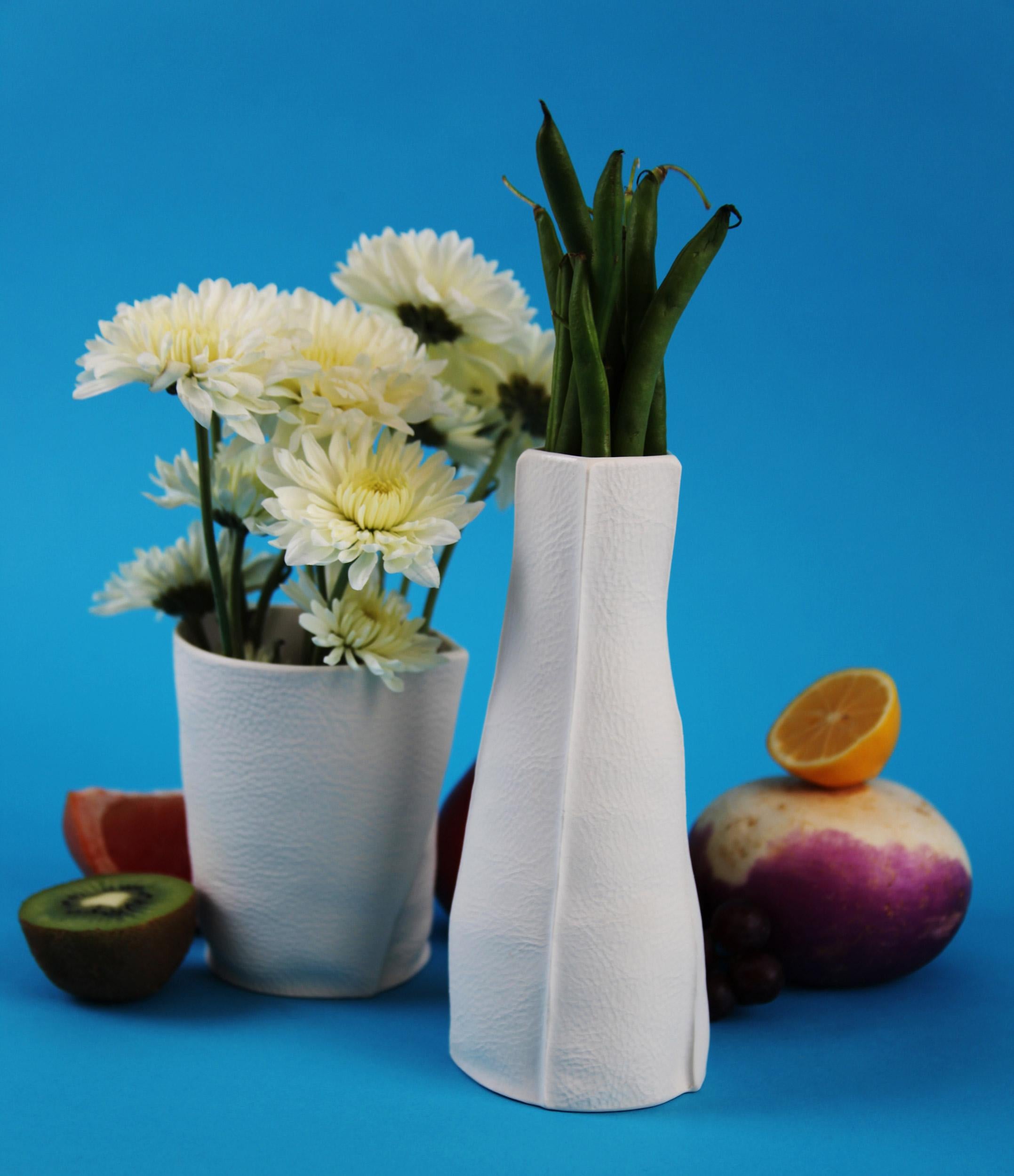Vase en porcelaine tactile et organique avec une surface extérieure texturée en cuir et un intérieur émaillé transparent. En raison du processus de production, chaque article est unique.

Utilisez-les individuellement pour un accent discret, ou en