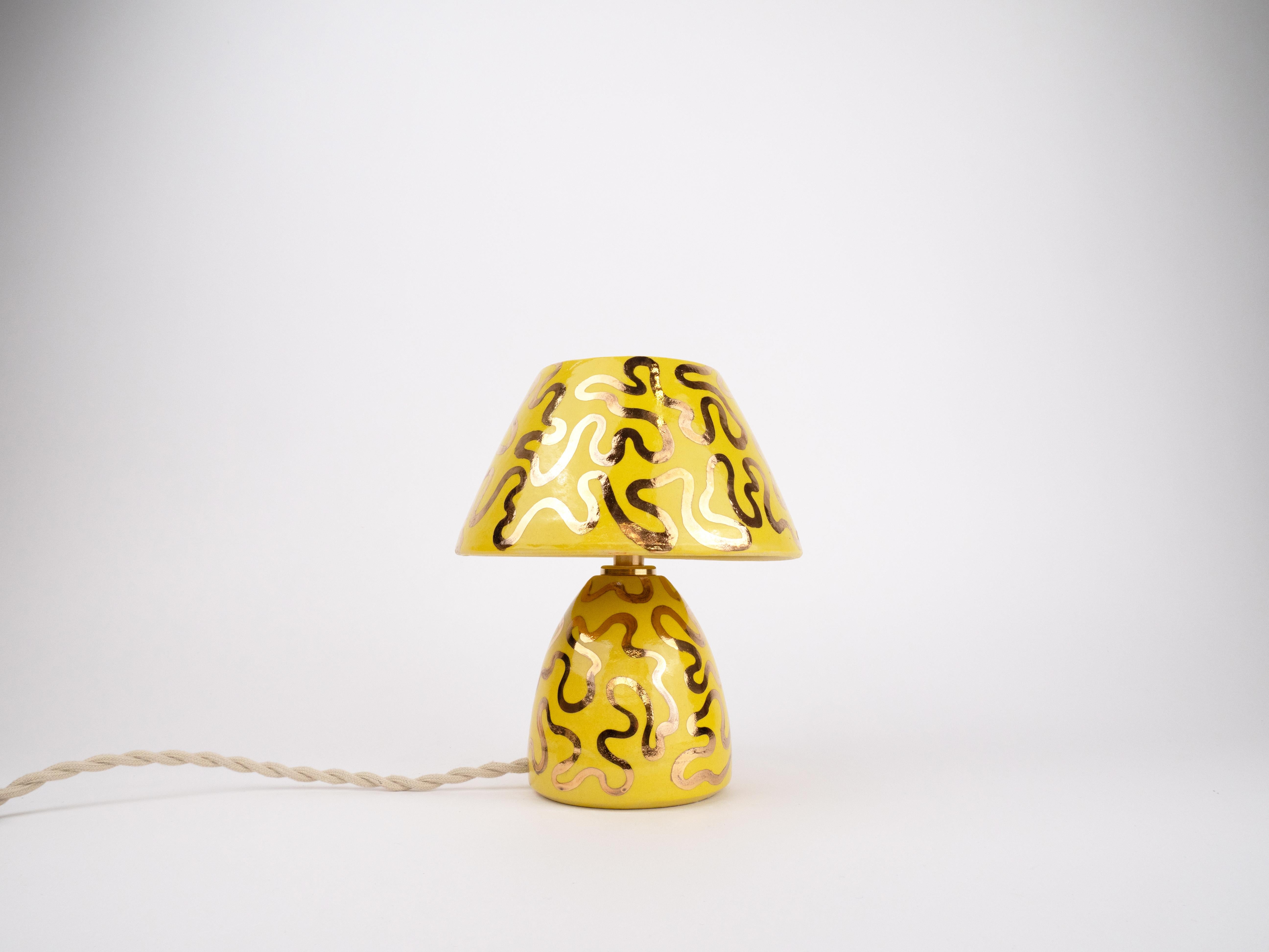 Brighten up your space with this unique handmade ceramic lamp, featuring a vibrant yellow glaze and playful 24k gold lustre wiggles. Its eye-catching design will be sure to add a warm, artistic touch to any space.

Bulb is included
Bulb fitting: