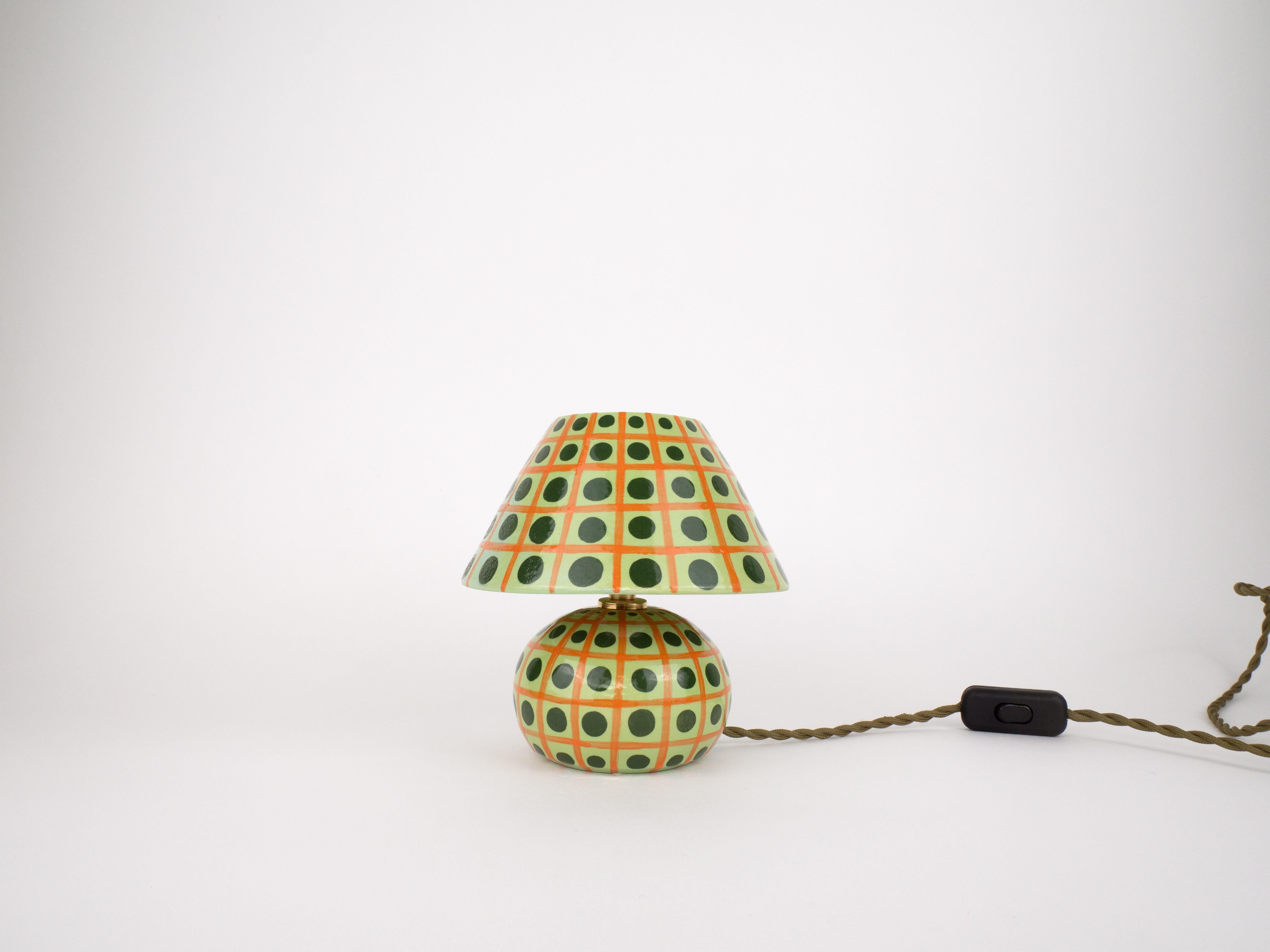 Aggiungi un tocco di colore al tuo spazio con questa lampada carinissima. Con una base in ceramica unica e lavorata a mano e un paralume coordinato, questo pezzo forte darà un tocco divertente a qualsiasi ambiente. Perfetta per comodini, scrivanie o