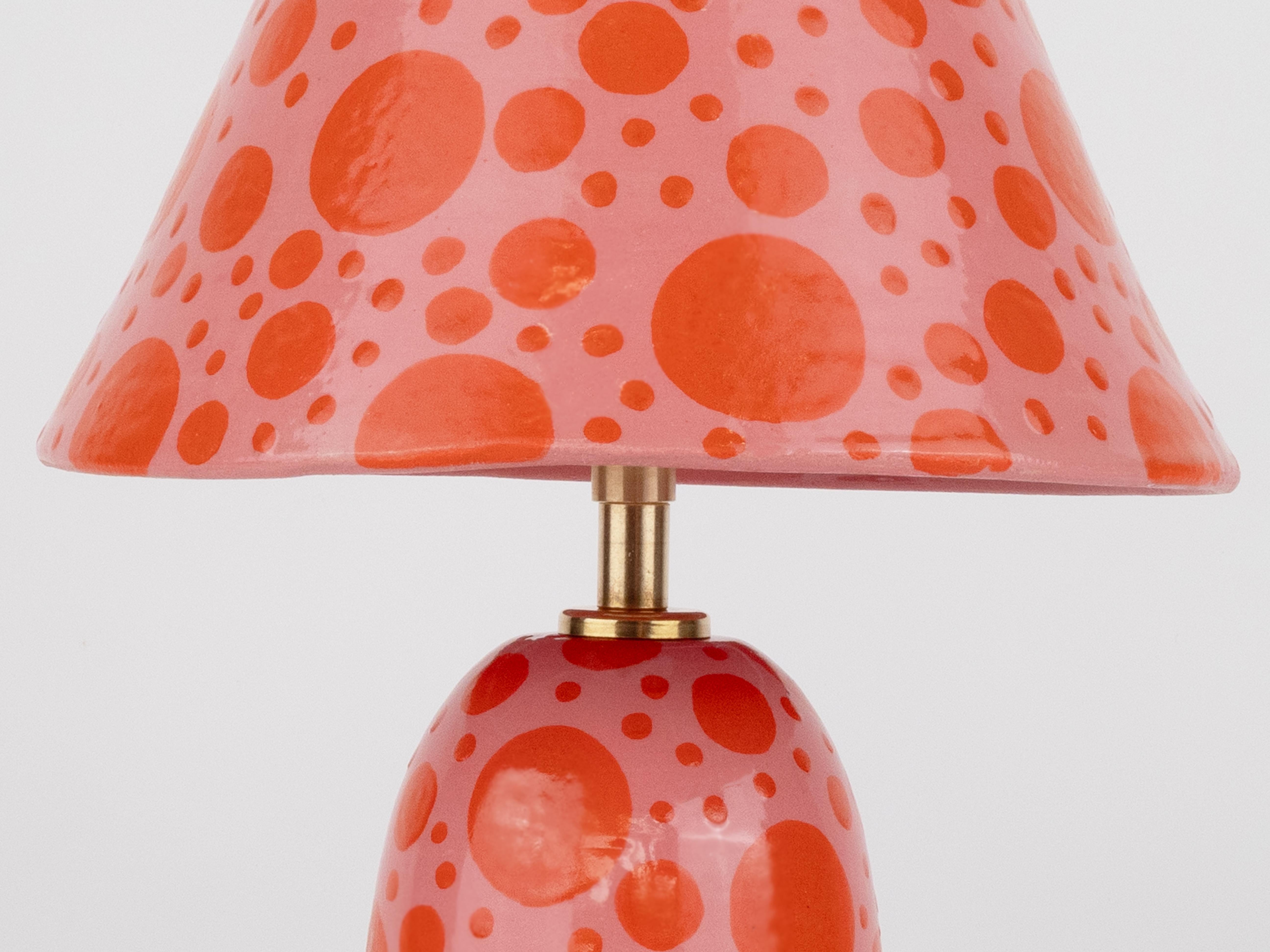 Bringen Sie Farbe in Ihren Raum mit dieser Lampe in leuchtendem Pink und Orange mit Tupfen. Mit ihrem einzigartigen, handgefertigten Keramiksockel und dem dazu passenden Schirm verleiht sie jedem Raum einen modernen und lustigen Touch. Perfekt für