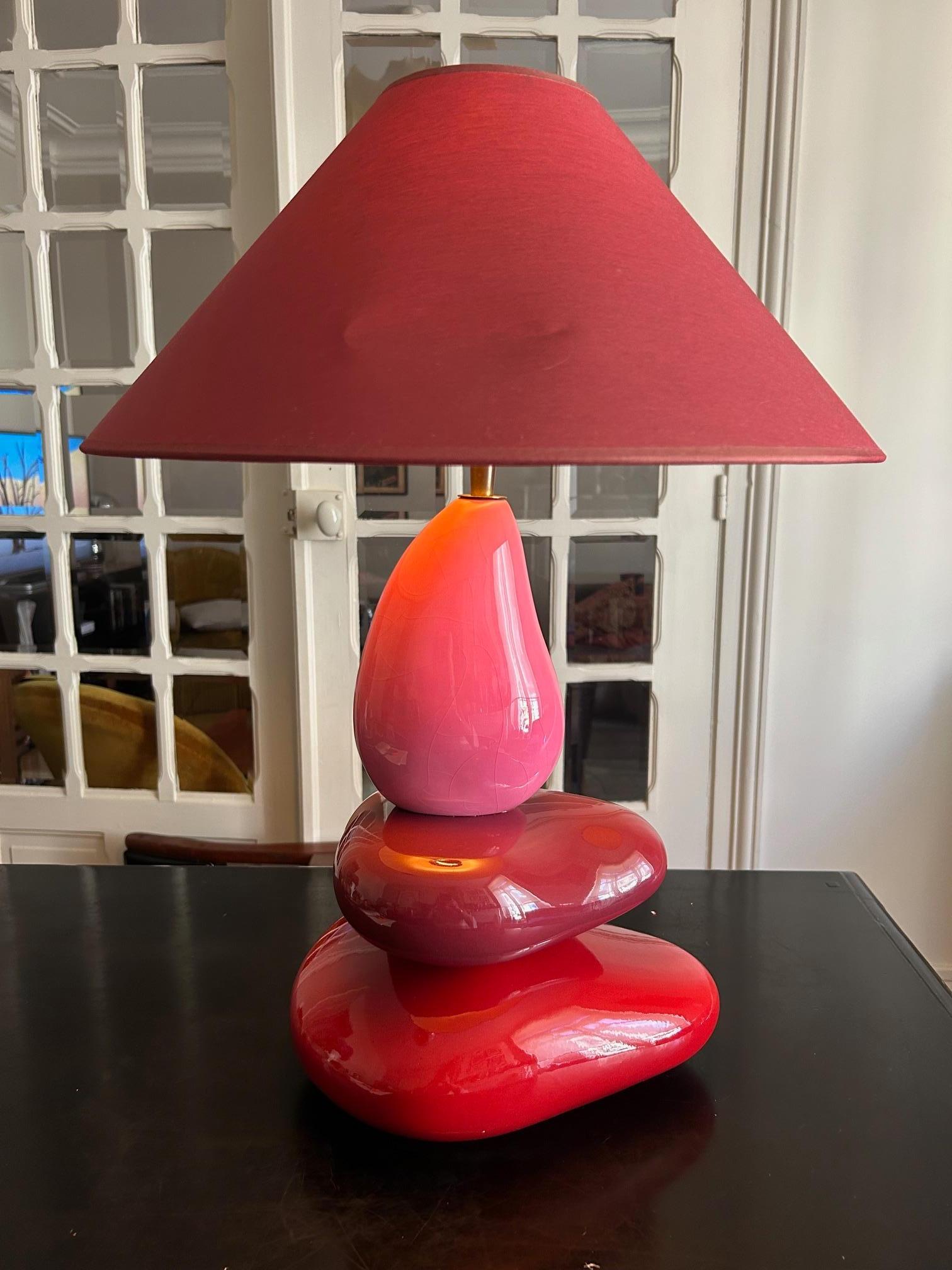 Pebble table lamp by François Chatain, 1980s France. 
Three ceramic pebbles in shades of pink, purple and red.
The angle of the shade is adjustable thanks to the brass ball joint mechanism. The original fabric shade has a small mark
Holds a E27