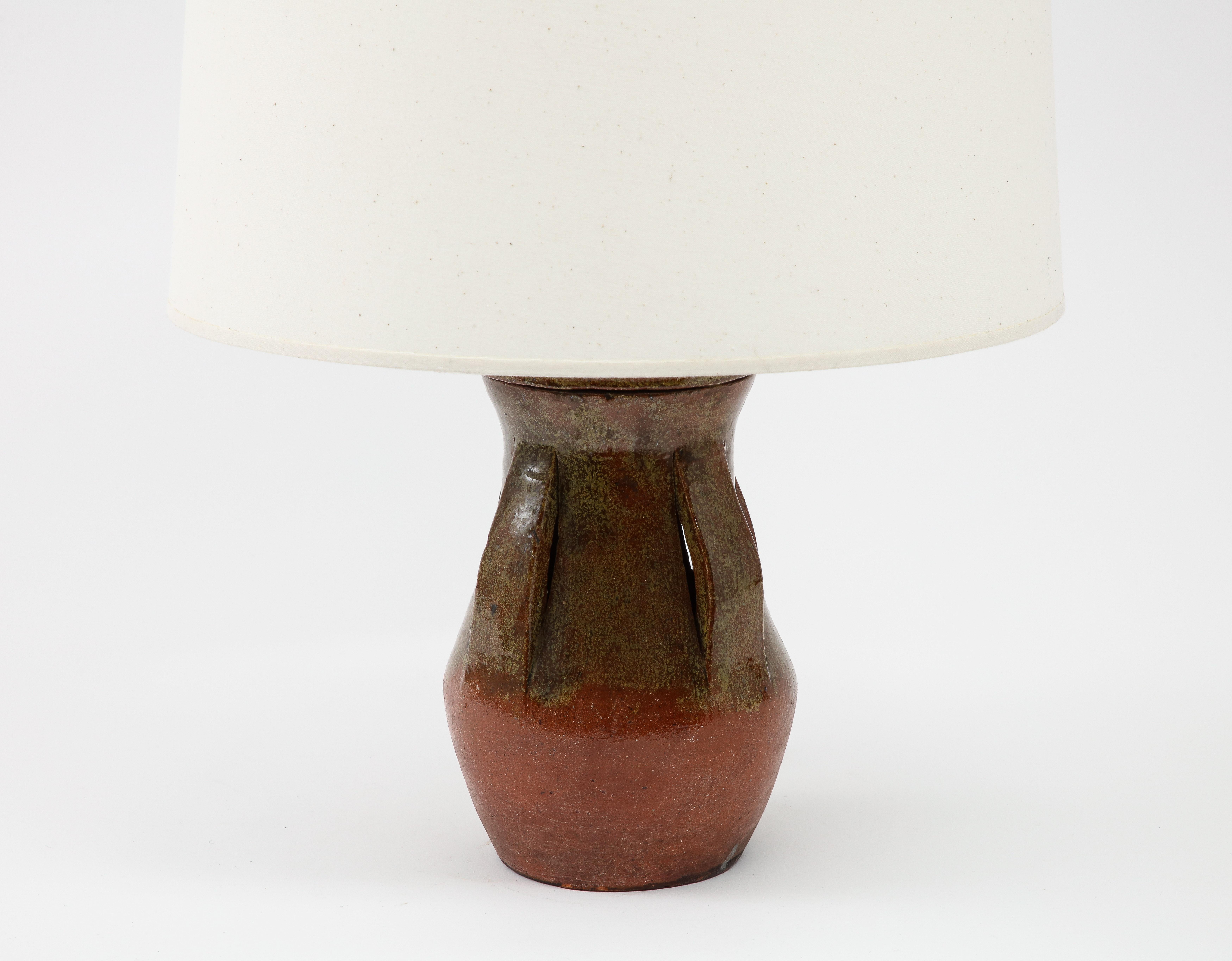 Circular ceramic table lamp in earthen tones glaze with ribbon decor. Rewired with keyed socked and silk cord. Base only 13