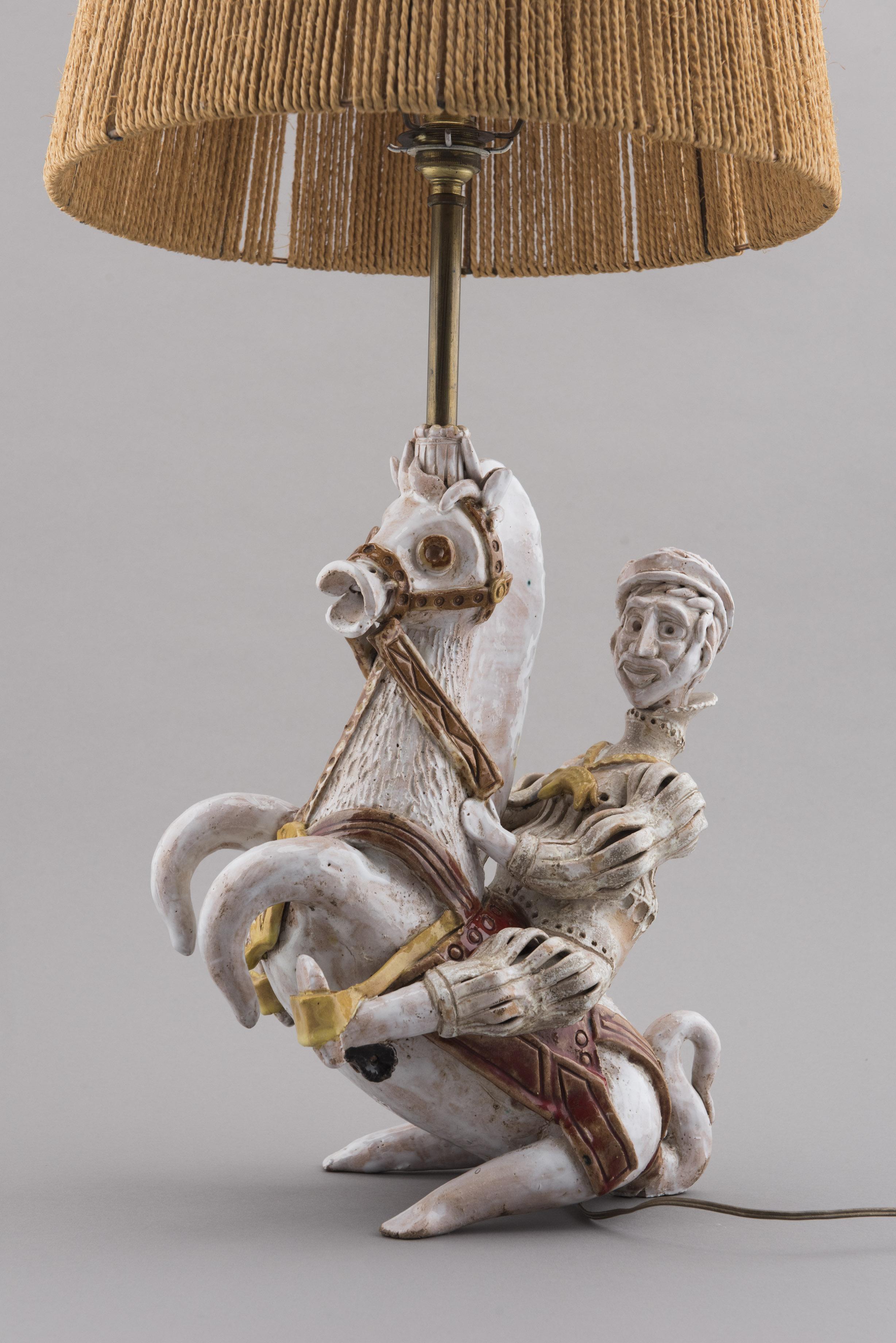 Lamp featuring a knight - as in chess pawn - in ceramic by André Marcharl in the 1950s Vallauris. Shade in cord.
The very limited series of Marchals work shows a clear interest for detail and movement.
On top of the horse, the sitting rider, there's