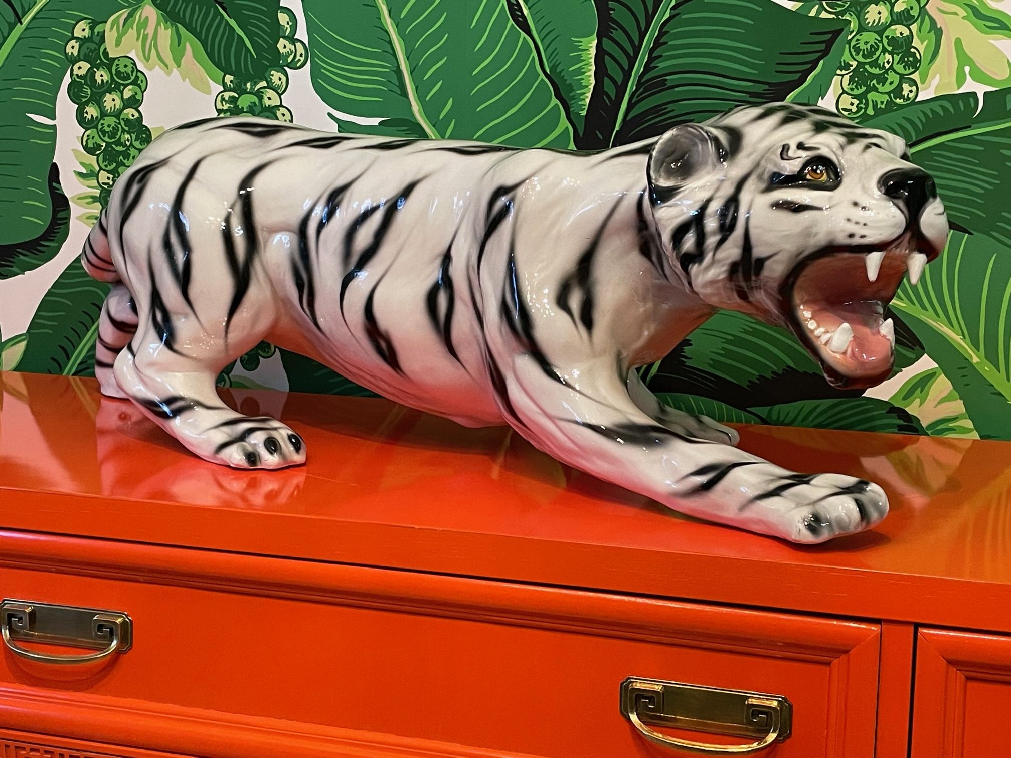 La grande statue de tigre blanc en céramique présente une gueule ouverte, une position de rôdeur et une belle finition en glaçure brillante. Bon état avec des imperfections correspondant à l'âge. Une réparation à la base de la queue qui est
