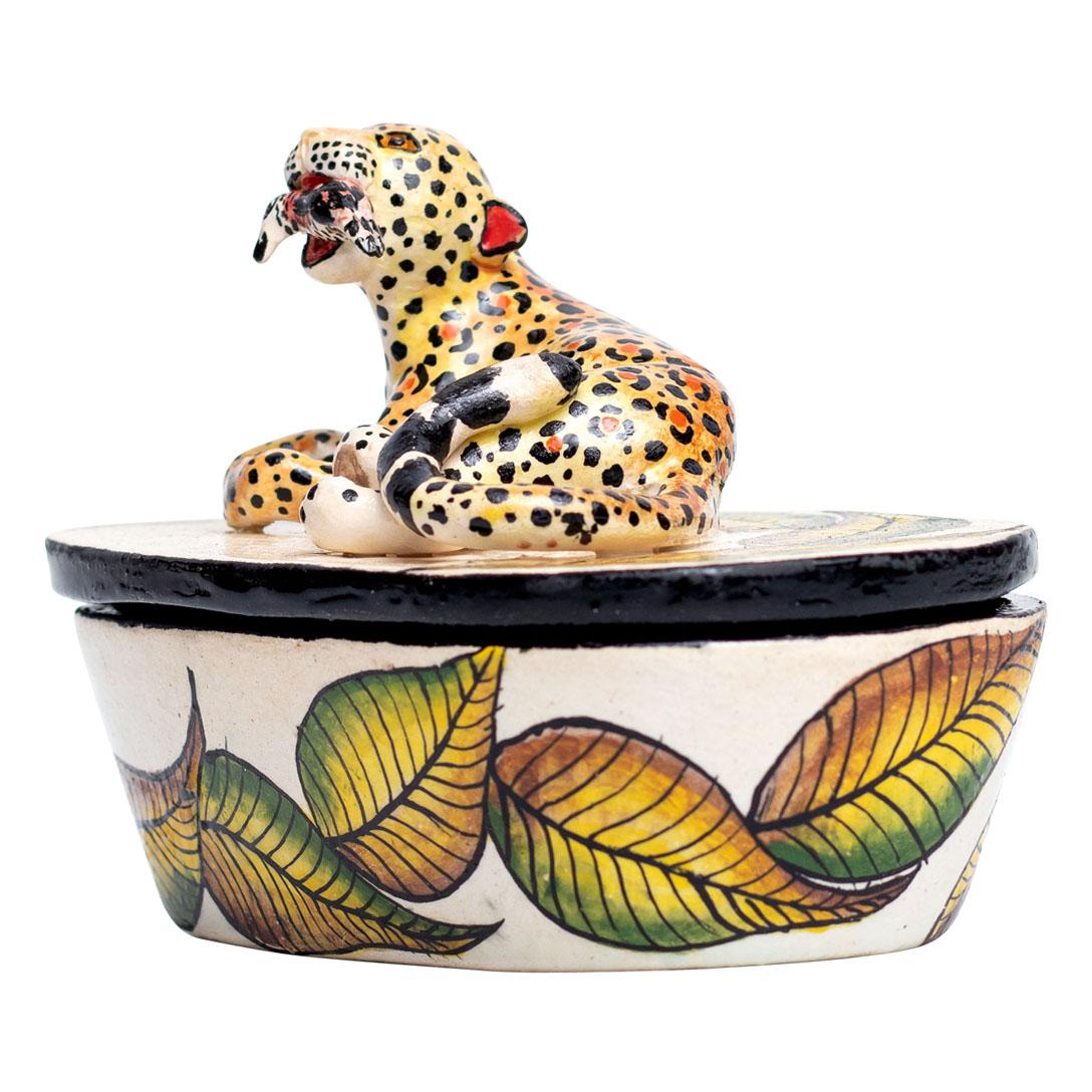 The ceramic leopard jewelry box from Wiseman Ceramics in South Africa is a unique piece crafted by skilled artisans Wiseman and Thabo. Hand-painted and hand-sculpted, it measures 4 inches high, 5 inches long, and 3 inches wide. The design