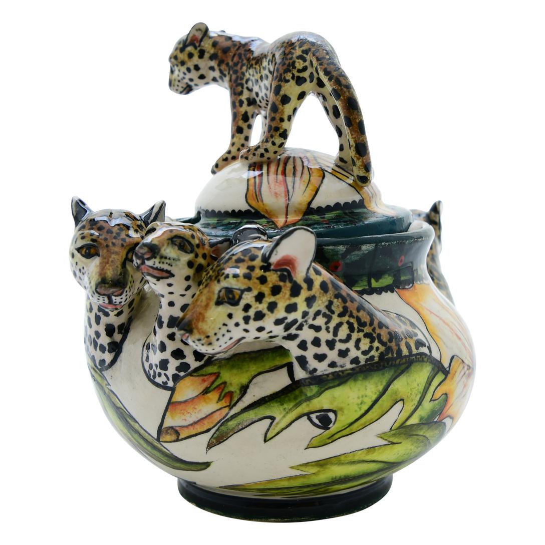 Fabriqué par Senzo Duma Ceramics en Afrique du Sud, ce pot à sucre en céramique en forme de léopard mesure 5 pouces de haut, 6 pouces de long et 4 pouces de large. Les talents de sculpteur de l'artisan Rever illustrent la grâce du léopard, un