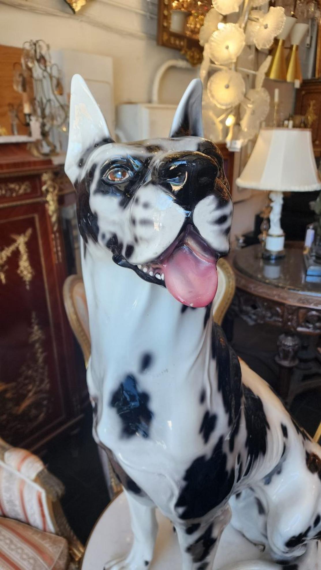 A life-size ceramic Harlequin Great Dane, hand painted from Italy that was most likely produced around 1970-1979. Harlequin Great Danes are a rare and unique variety of the Great Dane breed, characterized by its white and irregular black patches of