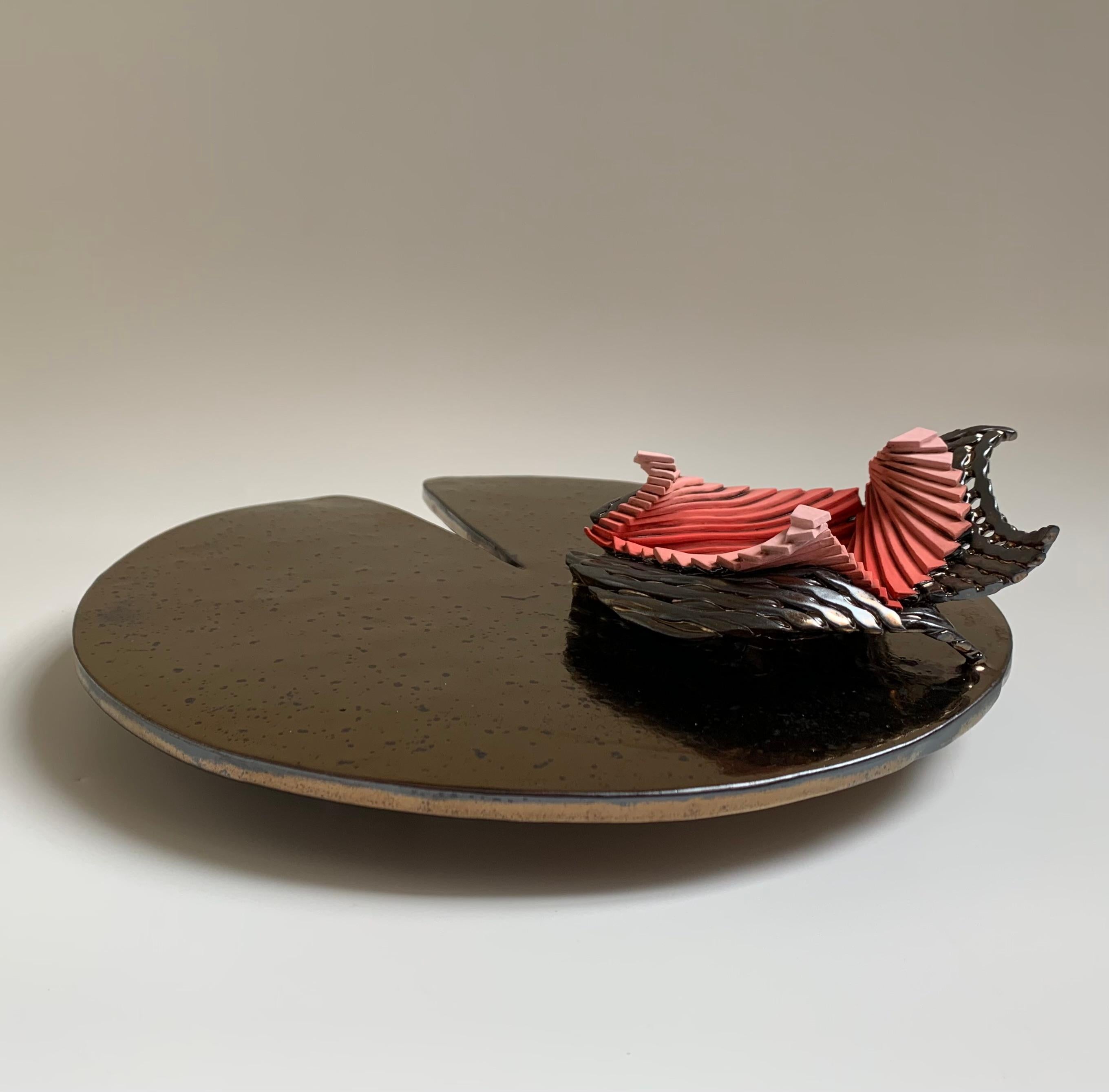 Ceramic lily pad is a handmade table sculpture. Finished in a gold / bronze glaze, the flower is glazed gradient style...starting with terra-cotta at the center, fading into red, into pink. Lily pad sculpture is handmade, with woven strands