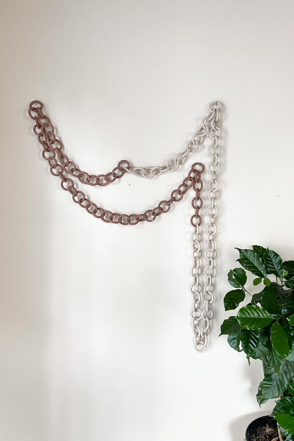 This eye-catching wall hanging adds a nomadic and mystical feel to any room. Created through a hand-intensive process of linking hand built stoneware rings of different sizes, this wall hanging is a dynamic decoration for an eclectic bedroom or