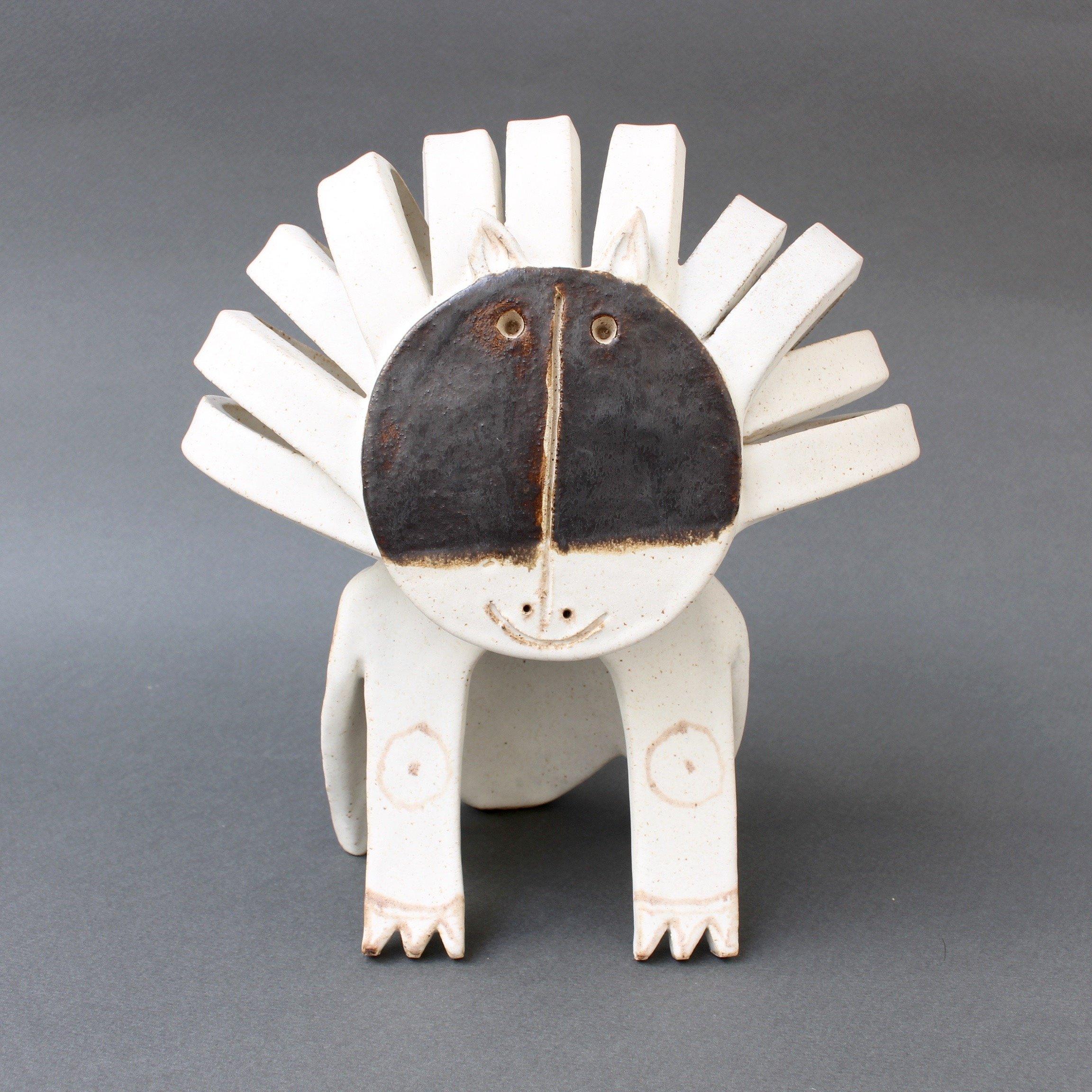 Smiling ceramic lion or cat sculpture by ceramicist Bruno Gambone, circa 1980s. This seated lion sculpture is truly a work of art. It is whimsical, yet beautiful in its use of the pared-down minimalist design elements. Its chalk-white colour adds to