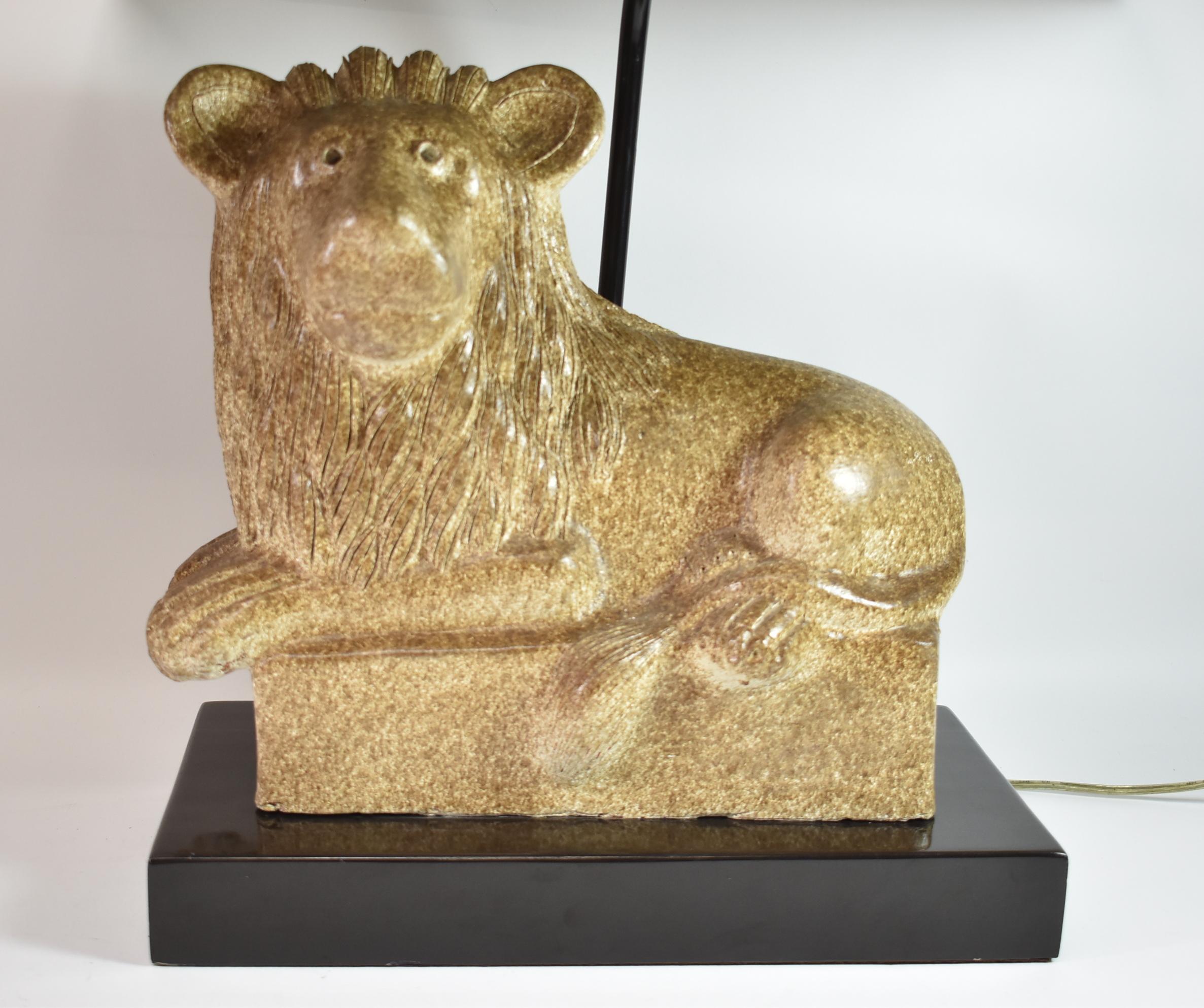 Keramik-Löwentisch in bunten Braun- und Cremetönen auf einem Sockel aus schwarzem Lack. Lampenschirm mit Schnurrahmen. Maße: 26 Zoll hoch x 8 Zoll breit an der Basis x 15 Zoll.
