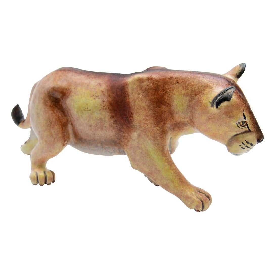 Introducing a captivating ceramic Lioness sculpture, meticulously hand-sculpted by Teboho and hand-painted by Virginia at Imvelo Natural Art, South Africa. Measuring 6 inches high, 14 inches in length, and 4 inches wide, this striking piece