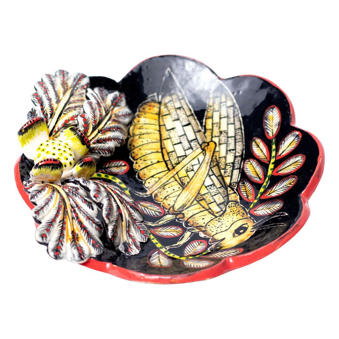 Locust Coin Dish
Hand Painted by Zinhle Nene and Sculpted by Sbusiso Ndaba
From Love Art Ceramic, South Africa (2024)

Introducing the Locust Coin Dish, a striking piece of ceramic art that captures the essence of South Africa's vibrant ecosystem.