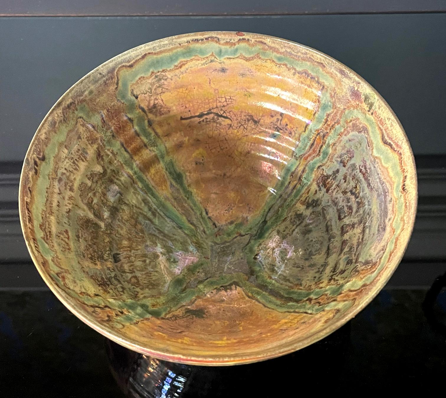 A large ceramic lusterware bowl by American artist and studio potter Beatrice Wood (1893-1998). The piece, circa 1980s, is of an upright deep form typical of a rice bowl, supported by a small foot ring. The surface was applied with brilliant