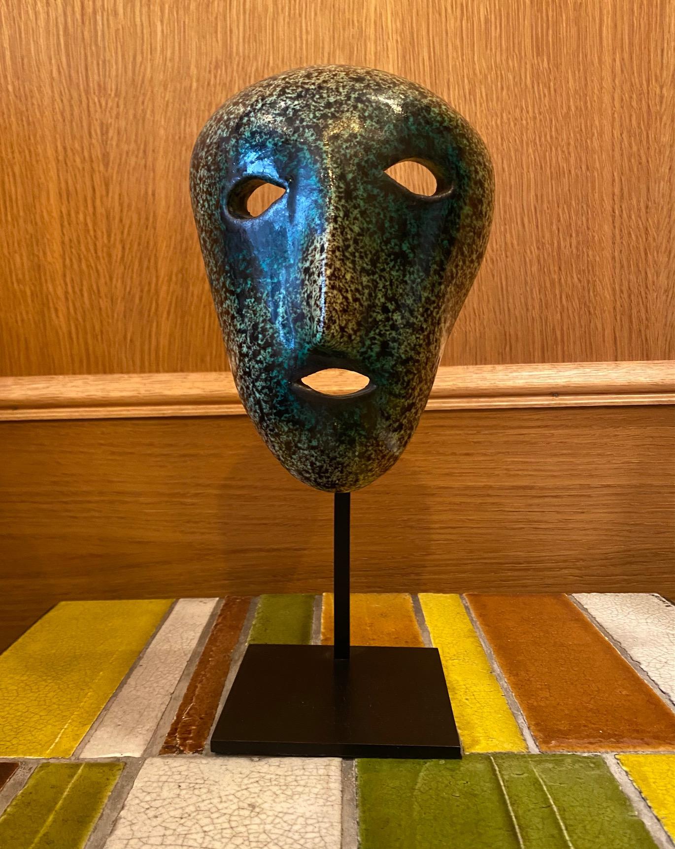 Masque en céramique, Accolay, France, années 1960
Accolay était un centre de poterie en France, au nord de la Bourgogne, fondé entre autres par 4 élèves d'Alexandre Kostanda. Actif entre 1945 et 1989.

Les dimensions indiquées sont avec le piédestal