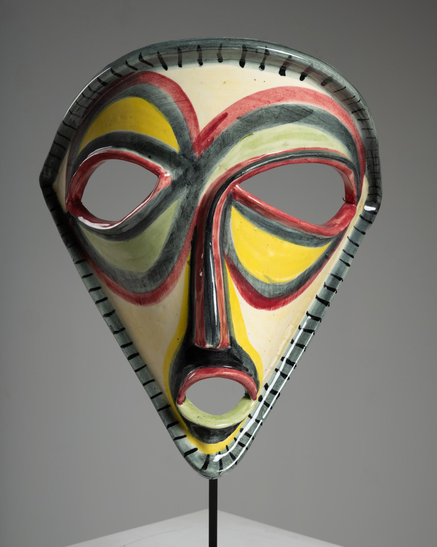 Maschera in ceramica smaltata di grande effetto creata dal rinomato laboratorio di ceramica Accolay, Francia, circa 1960. Con un'altezza di 49,5 cm e una larghezza di 32 cm, questo pezzo scultoreo esemplifica l'audace creatività e la maestria per