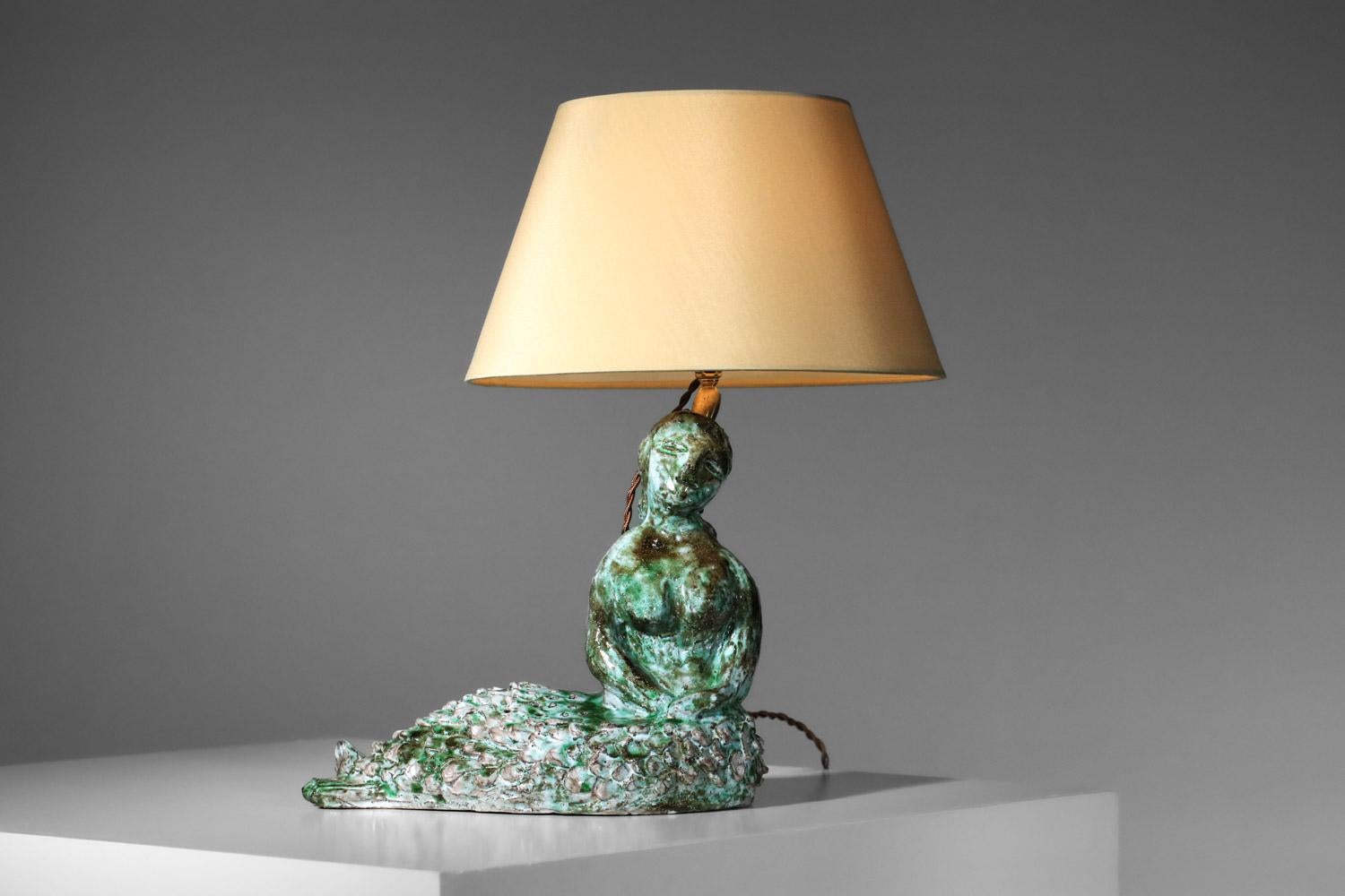 Ceramic attributed to Guidette Carbonell dating from the 60s. Ceramic with a base used as a bougoire representing a mermaid enamelled in green and blue shades, mounted as a lamp in the past. Electrical system refurbished, we recommend a B22 LED