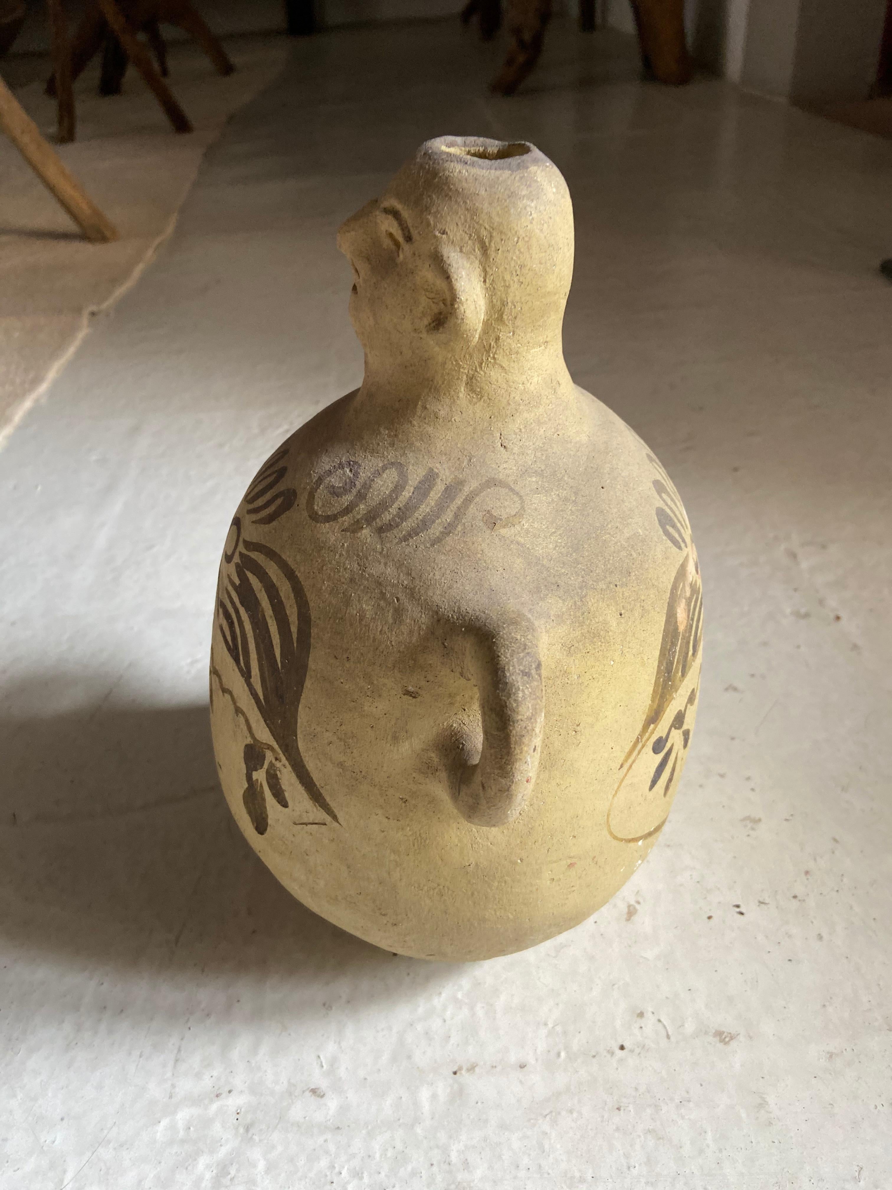 Hand made ceramic jug for carrying mezcal or pulque from Tuliman, Guerrero, circa 1970s. Canteen-type jug with hoop arms used for rope or strap ties. A cork or stopper would typically be placed on the vessel's head.
