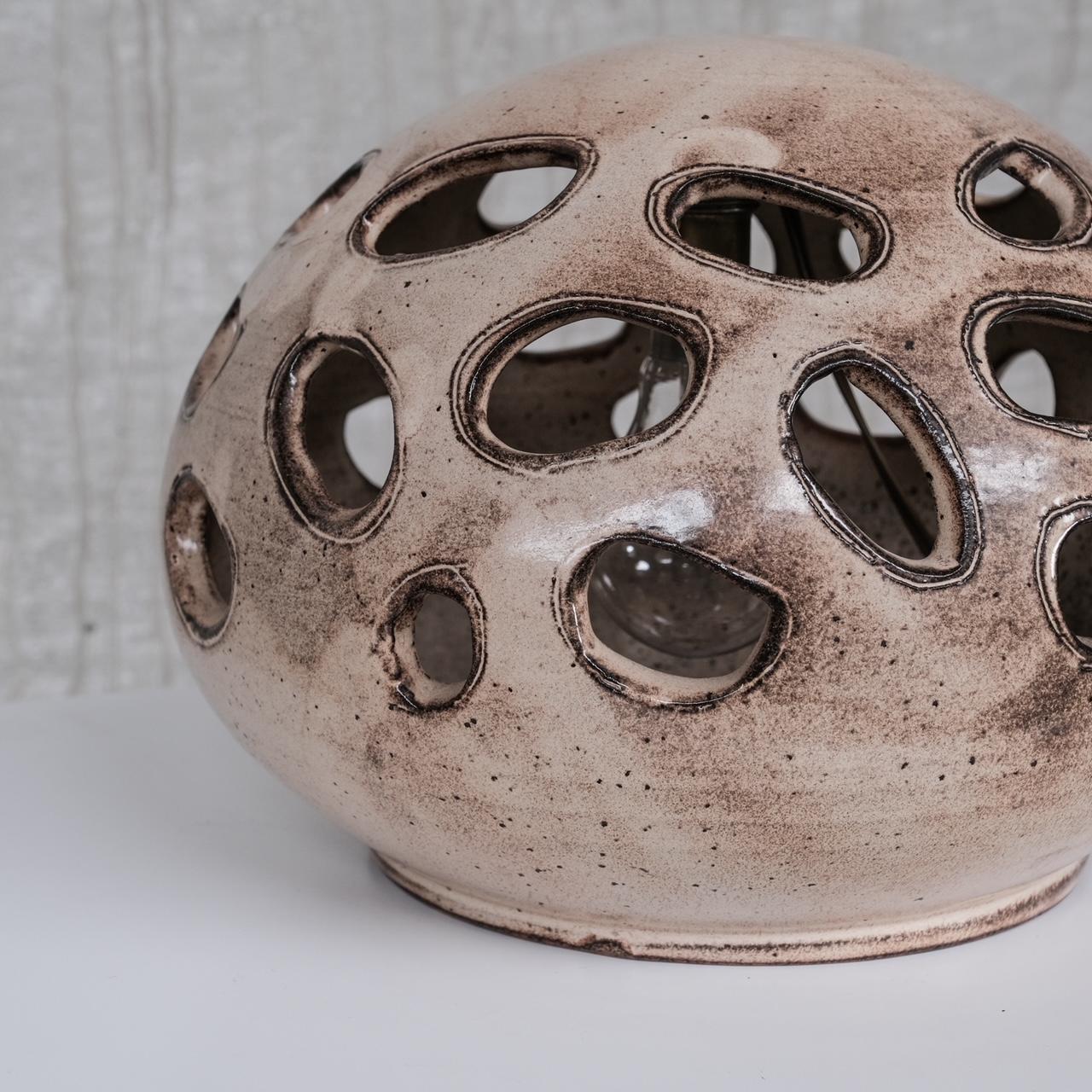A ceramic table lamp of unusual form, likely artist made. 

France, c1960s. 

Perforated holes in the ceramics allow for diffusion of the light. 

Since re-wired and PAT tested. 

Good condition. 

Location: Belgium Gallery.