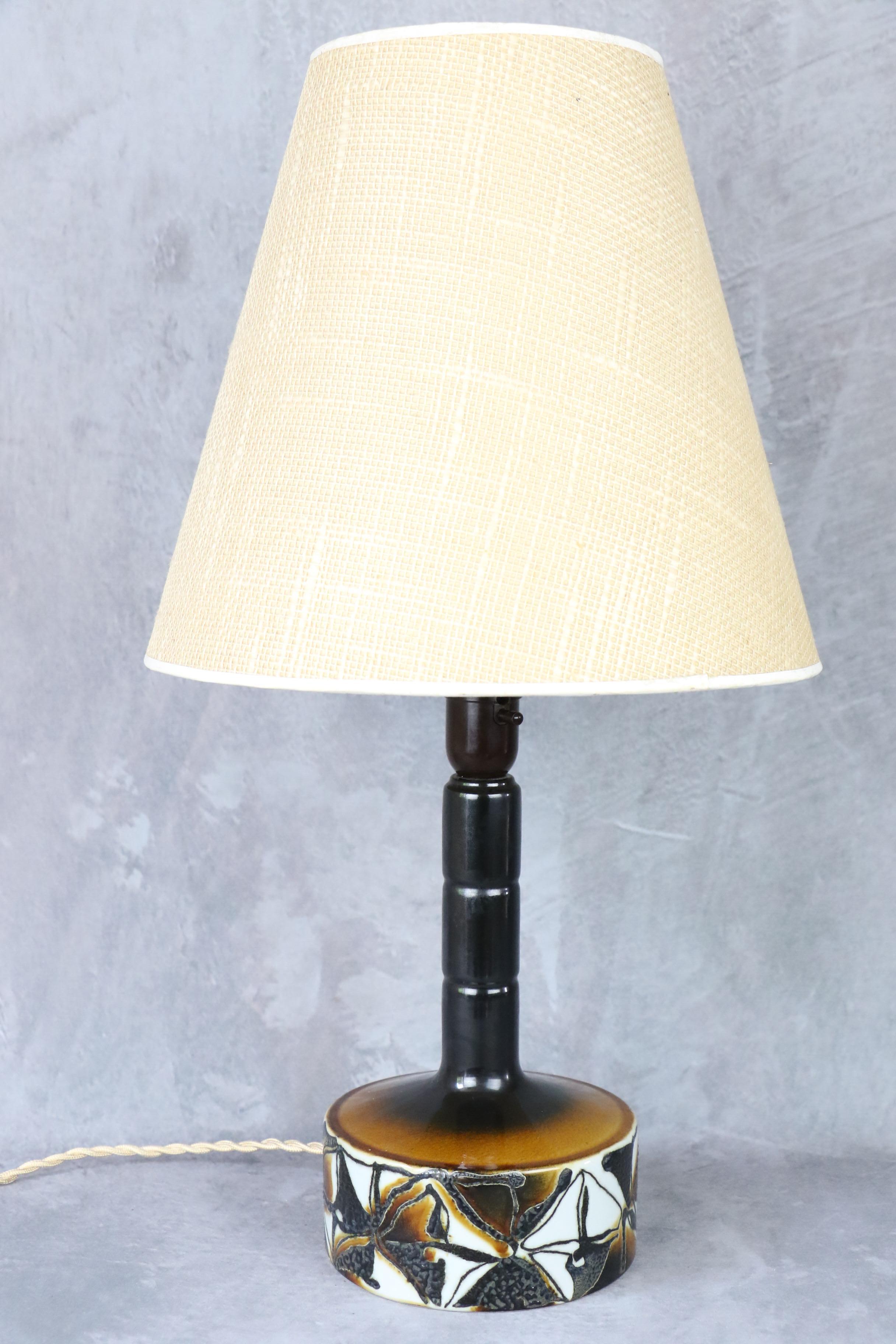 Ceramic Midcentury Lamp by Royal Copenhagen, Denmark, 1960s

Bell Danish lamp by Royal Copenhagen, it is enamelled in autumnal colours and has an elegant play of textures between a smooth white enamel and a slightly granulated black enamel.

It