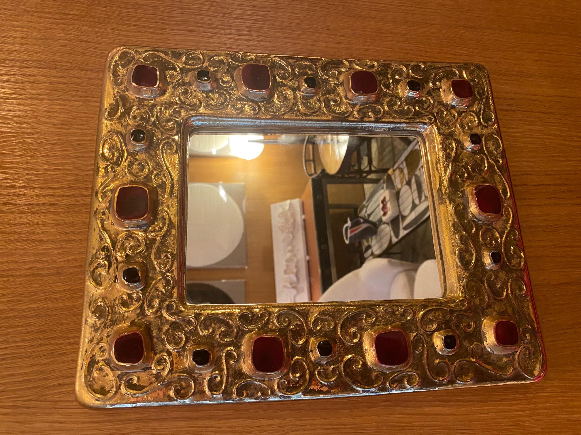 Ceramic Mirror by François Lembo, 1970s
Gilted ceramic with red cabochons. Signed in the back
François Lembo was active in Vallauris, south of France from 1960s until his death