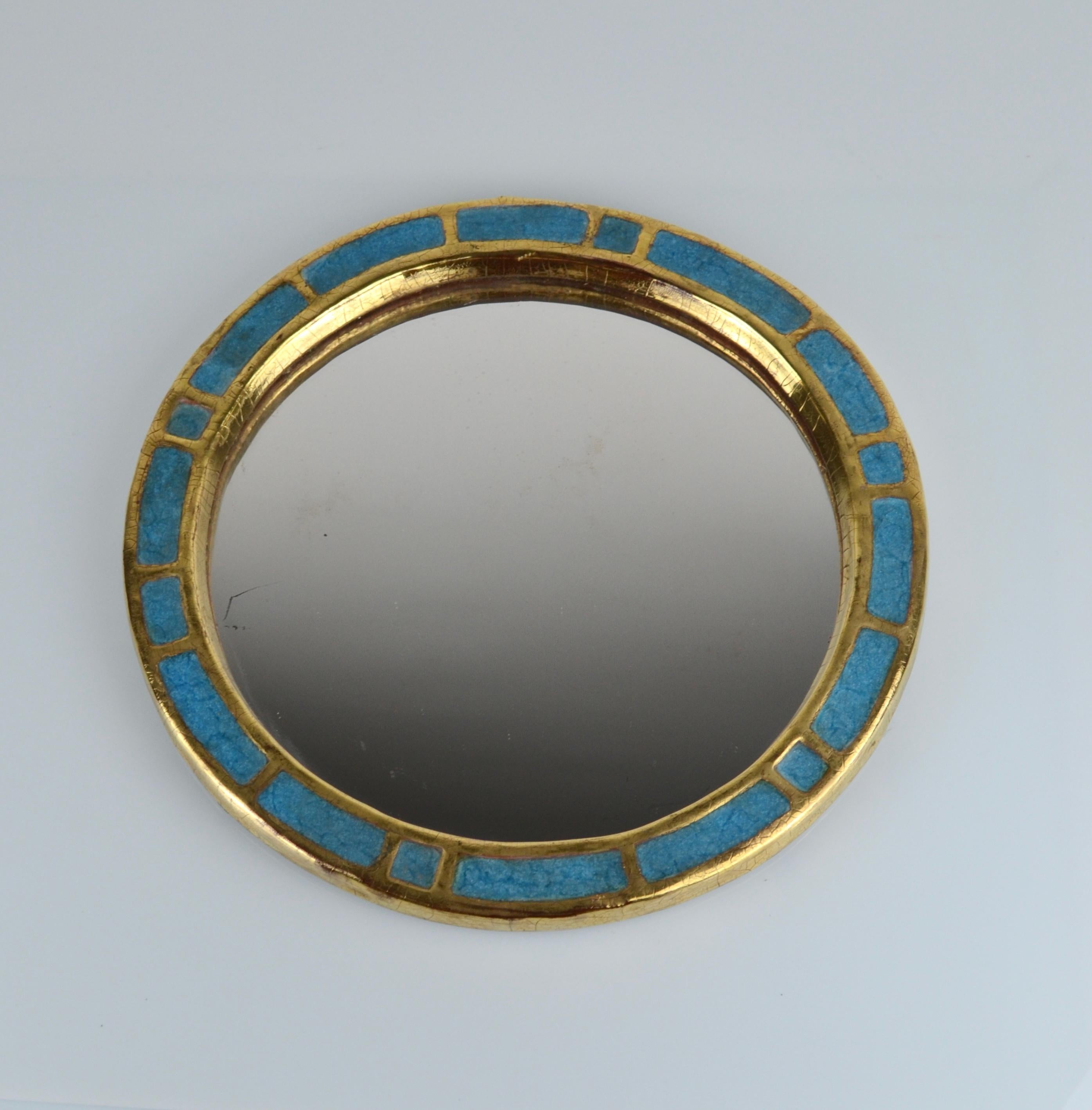 Mithé Espelt, miroir en céramique, vers 1960, France.
Faïence émaillée et gaufrée.
Céramique bleue et dorée craquelée.
Support original en feutre.

