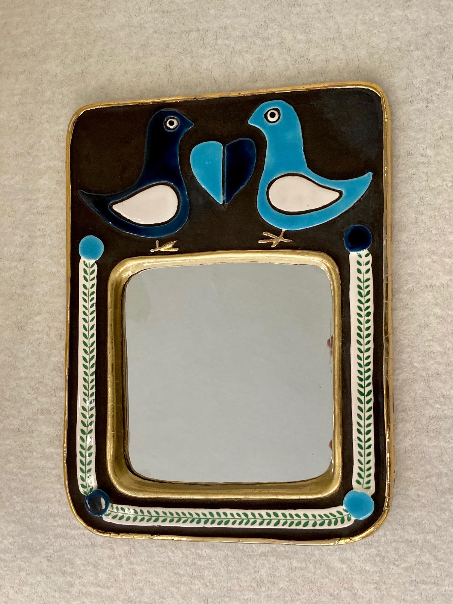 Un miroir mural en céramique, 2 oiseaux se faisant face avec un cœur au milieu.
 Émaillé en 2 tons de bleu, blanc, noir et or.
Mithé Espelt (née en 1923)
Lunel, sud de la France,
vers 1970
Cette œuvre d'art poétique témoigne du talent de Mithé