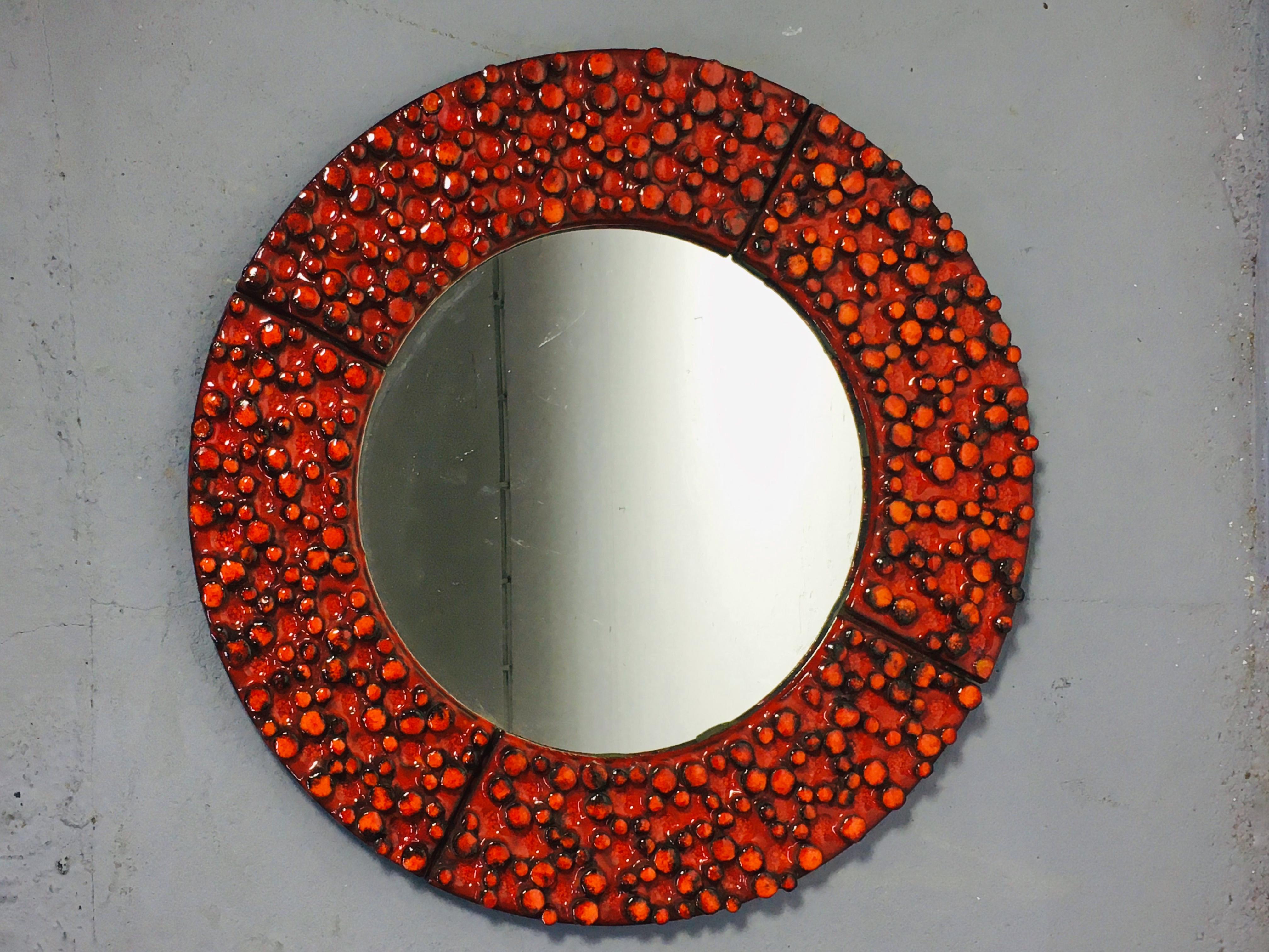 A ceramic framed mirror designed and made by Oswald Tieberghien, one of Belgium's most famous ceramist. Very rare piece of his work. Its large, red-glazed, relief surface is perfect for both modern and vintage interiors. Available in perfect