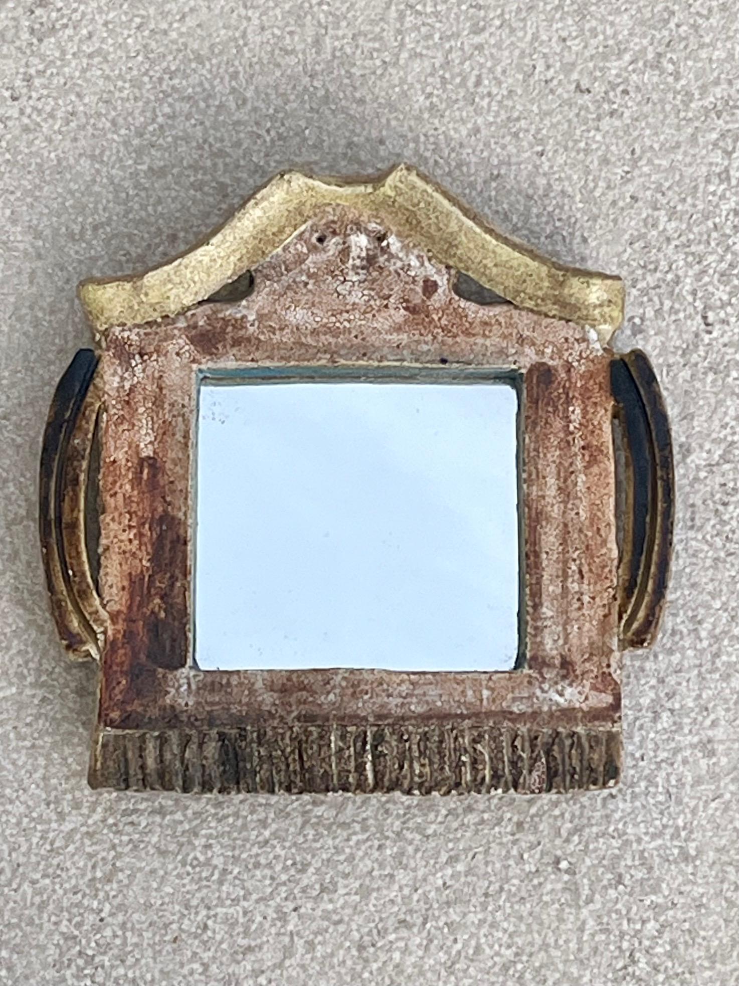 Ceramic mirror.
Glazed ceramic in shades of blue, ochre and yellow.
Architectural construction with pediment at the top.
Underneath, a stylized face can be seen with eyes and nose ( see detail photo) 
 Signed at the back 