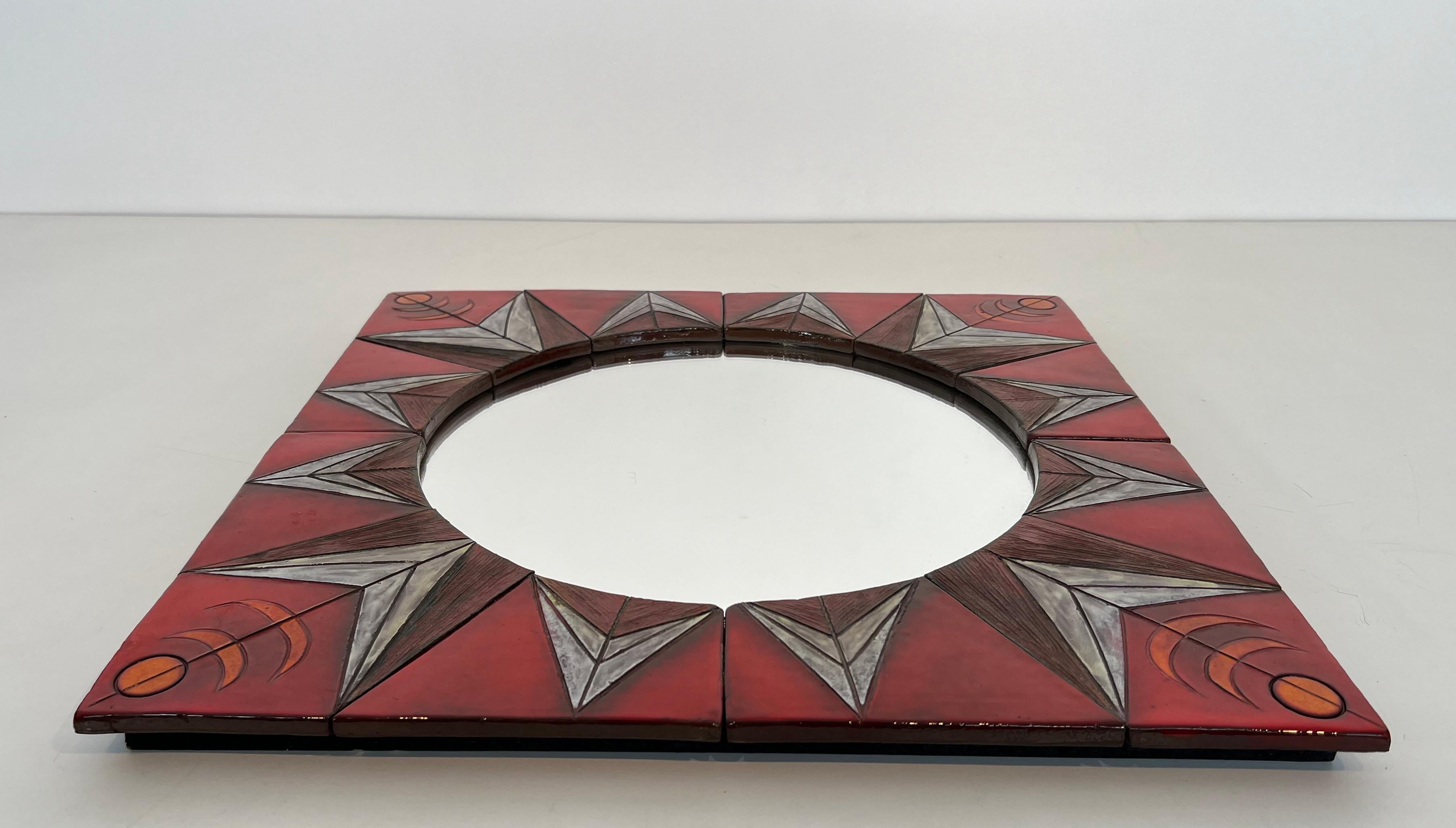 This very nice mirror is made of ceramic. It represents a stylized sun on a red background. This is a Belgian work attributed to Oswald Tiberghien. Circa 1960
