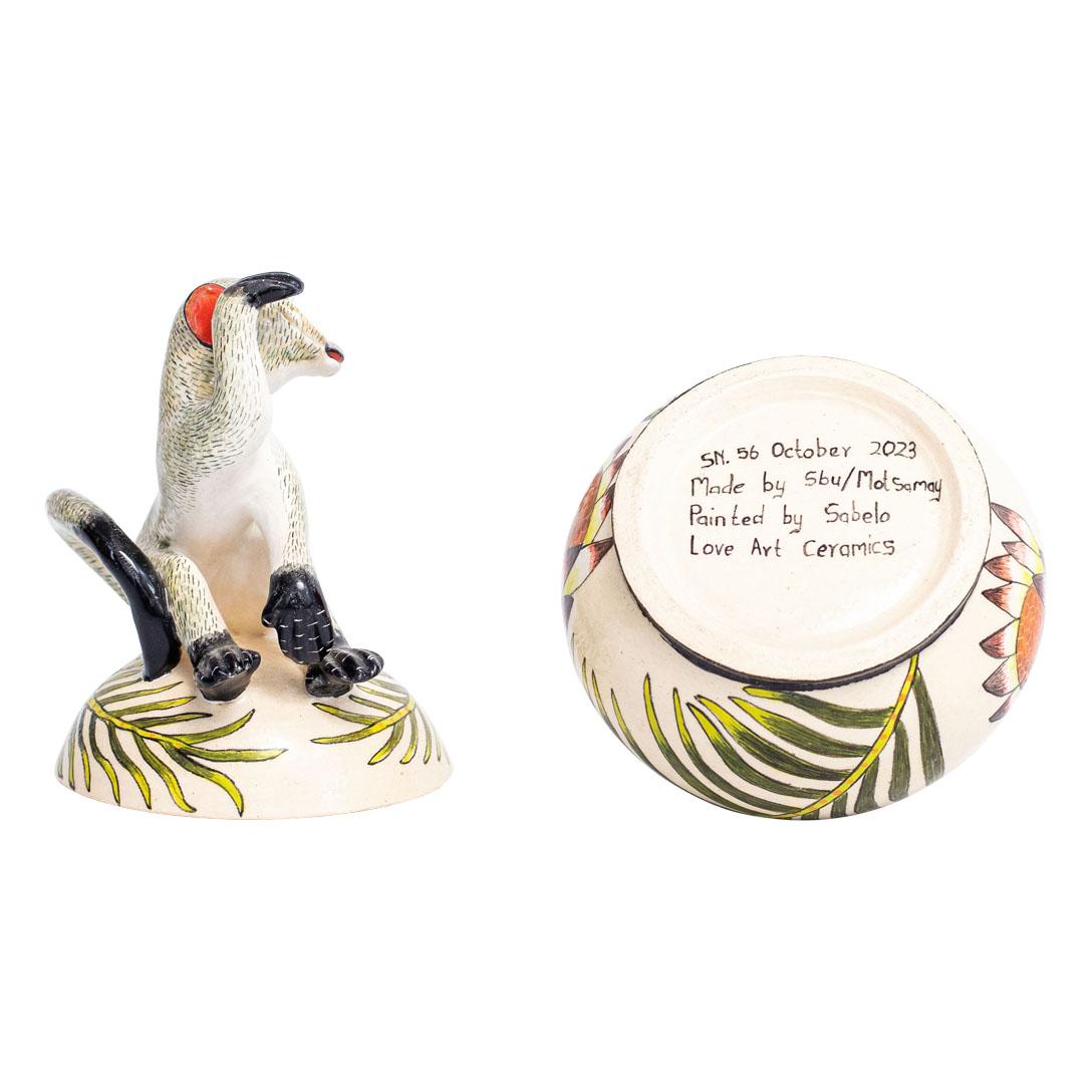 Dieses Keramik-Schmuckkästchen Monkey, handgefertigt von Sabelo Nene im Love Art Ceramic Studio in Südafrika, ist 6 Zoll hoch, 4 Zoll lang und 4 Zoll breit. Es wurde 2023 entworfen und spiegelt die Lebendigkeit der afrikanischen Natur wider.