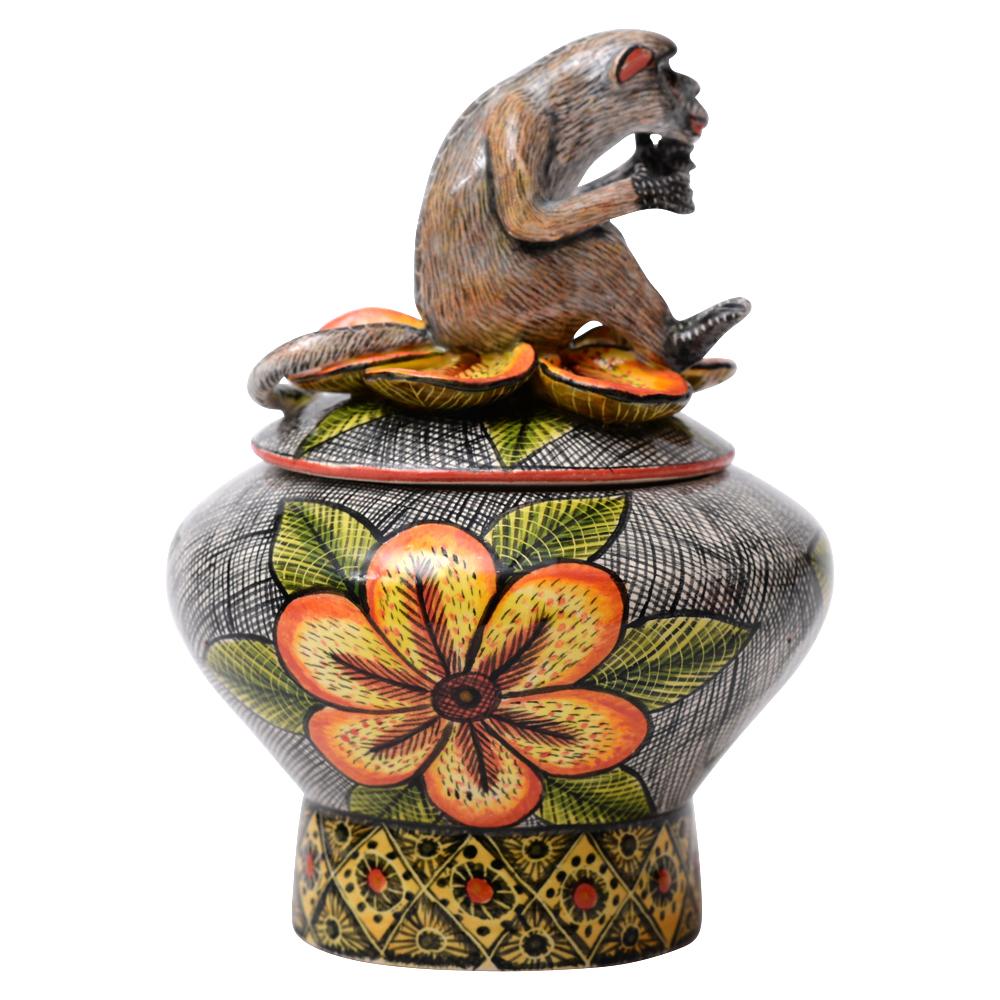 Experience the vibrancy of African culture with the Monkey Novelty Box by Love Art Ceramics. Hand-sculpted and painted by Jabu Nene in South Africa, this whimsical piece showcases intricate details and a Zulu-inspired pattern. The monkey seated on a