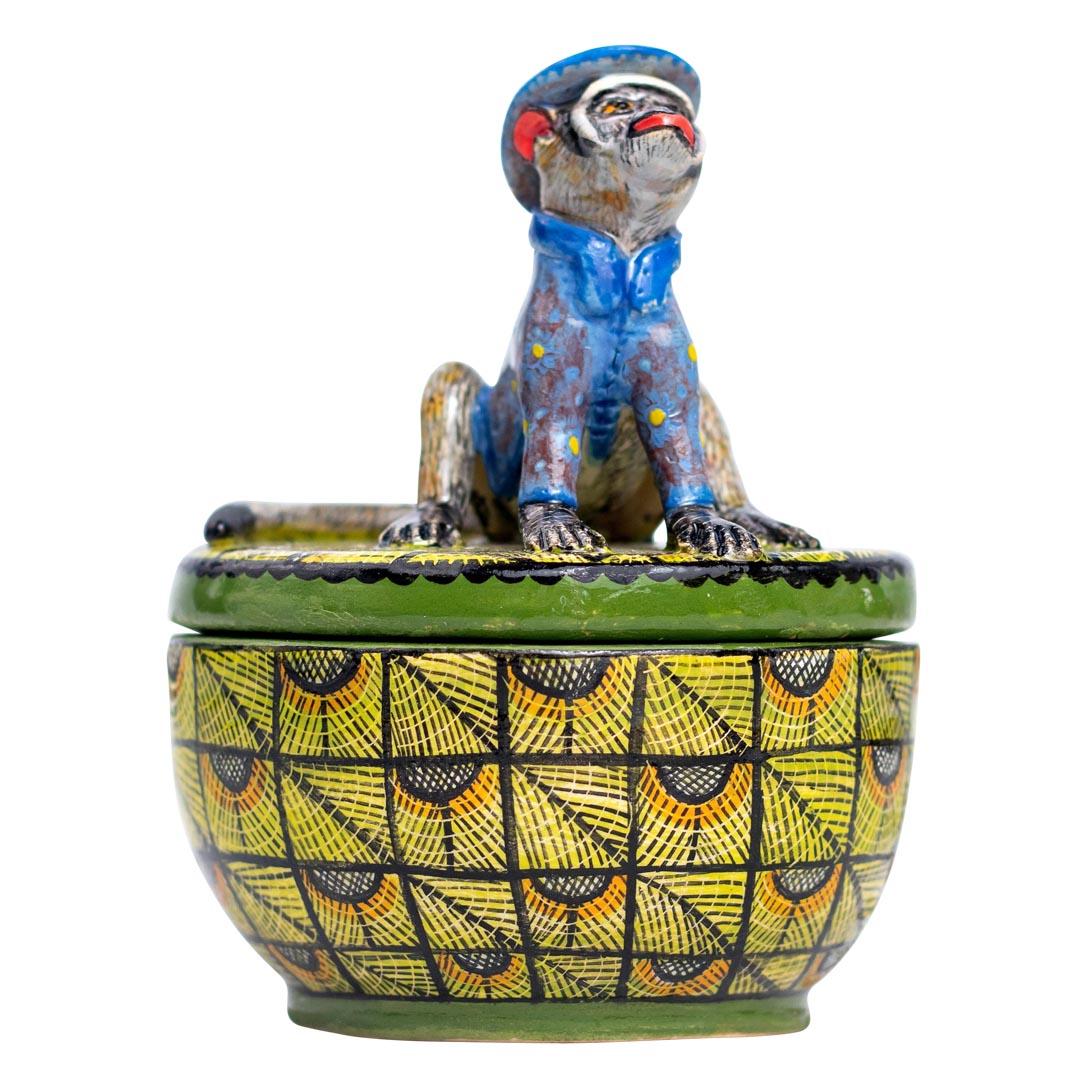 This charming ceramic jewelry box is a testament to both artistry and collaboration. Standing 4 inches tall and 3 inches wide, the box features a unique design that combines functionality with creative flair. The highlight of the piece is its