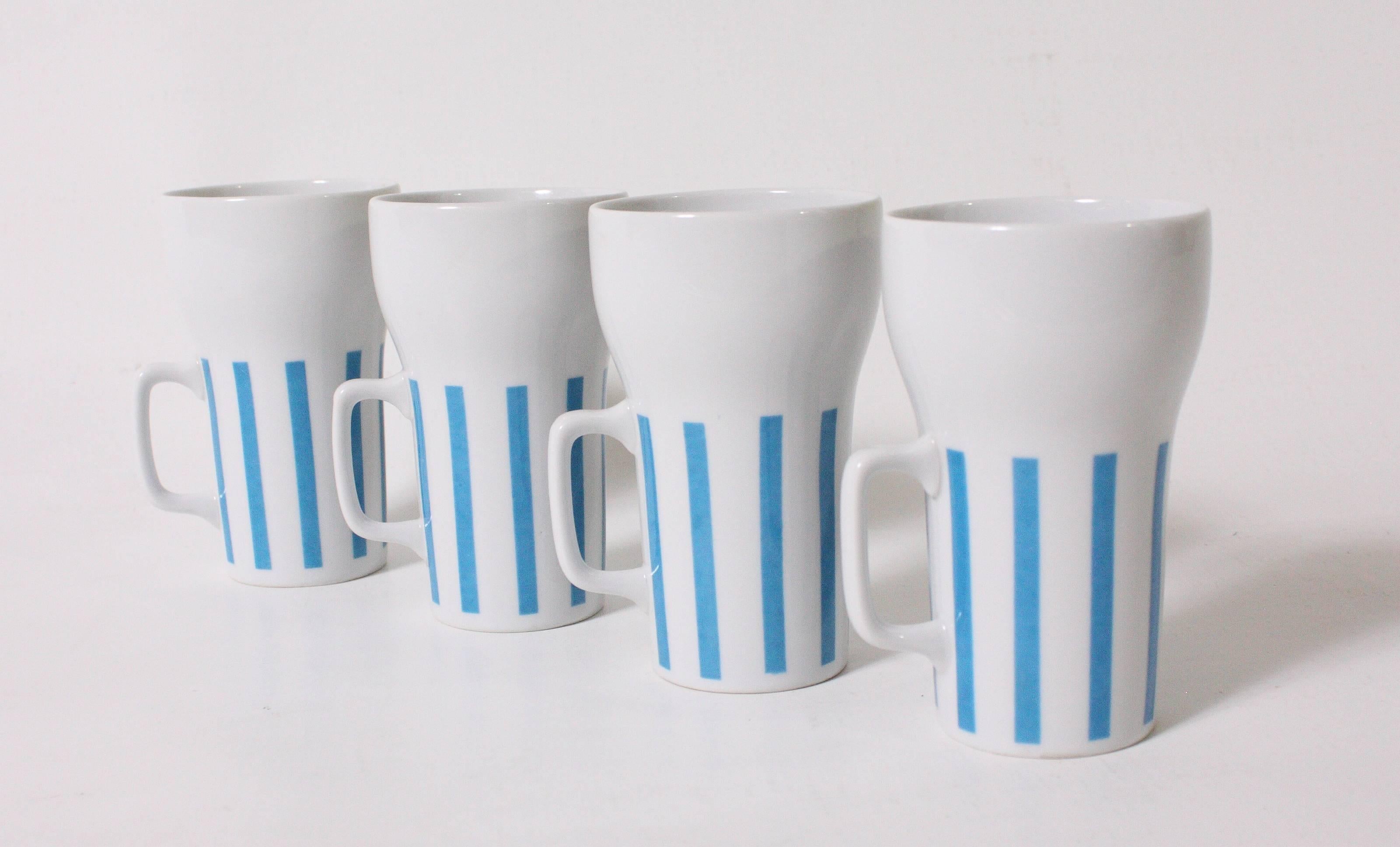Set of four white mugs and tumbler with blue vertical stripes by Lagardo Tackett. Tumbler measures: 10