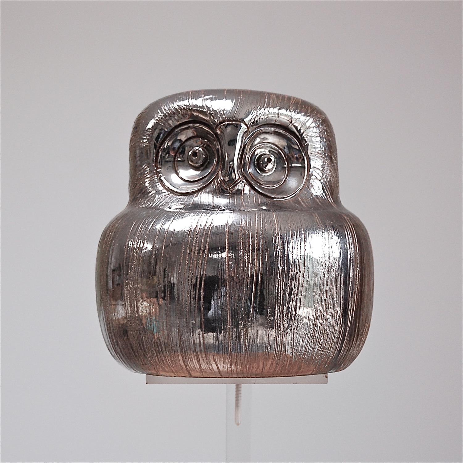 A handmade ceramic owl designed by Aldo Londi for Bitossi in the 1960s. This characterful owl figurine is made from red terracotta clay with lines engraved by hand and finished with a silver metallic glaze highlighting the fine-grained structures on